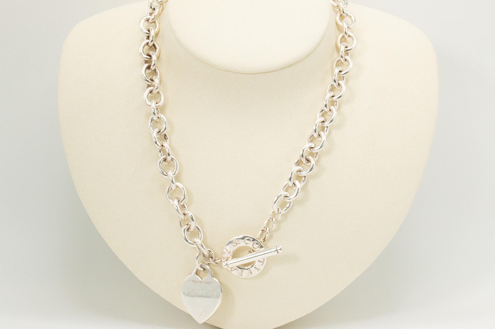 Vintage Tiffany & Co Sterling Silber Blank Herz Toggle Chocker Halskette

Diese Vintage Tiffany & Co. Die Heart Tag Toggle Choker Necklace ist ein ikonisches Schmuckstück, das fachmännisch aus massivem 925er Sterlingsilber gefertigt und mit der