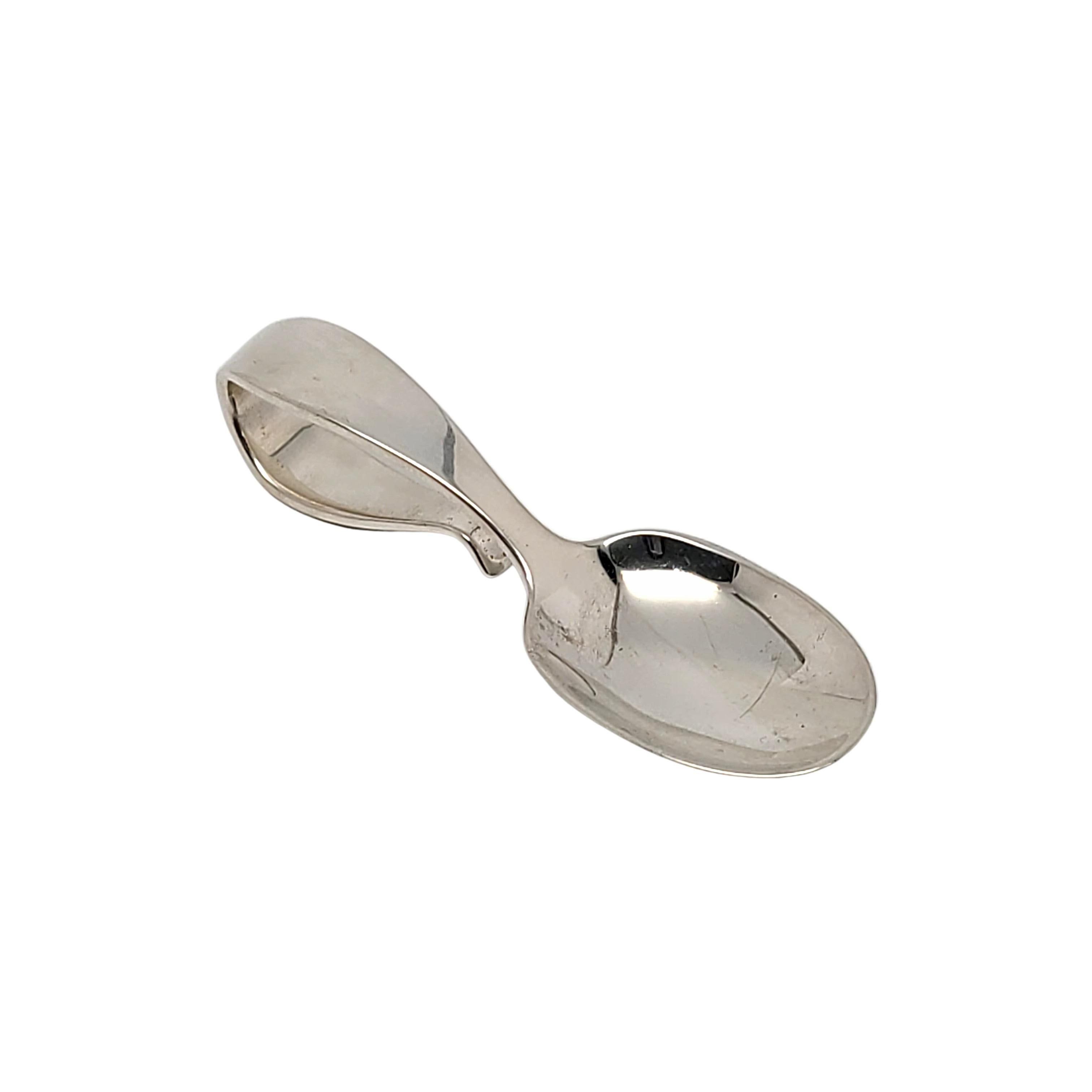 Tiffany & Co sterling silver curved handle baby feeding spoon with pouch.

No monogram

A simple and classic design featuring a curved loop handle. Hallmarks date this piece to 1907-47 under the directorship of John C Moore II. Includes Tiffany & Co