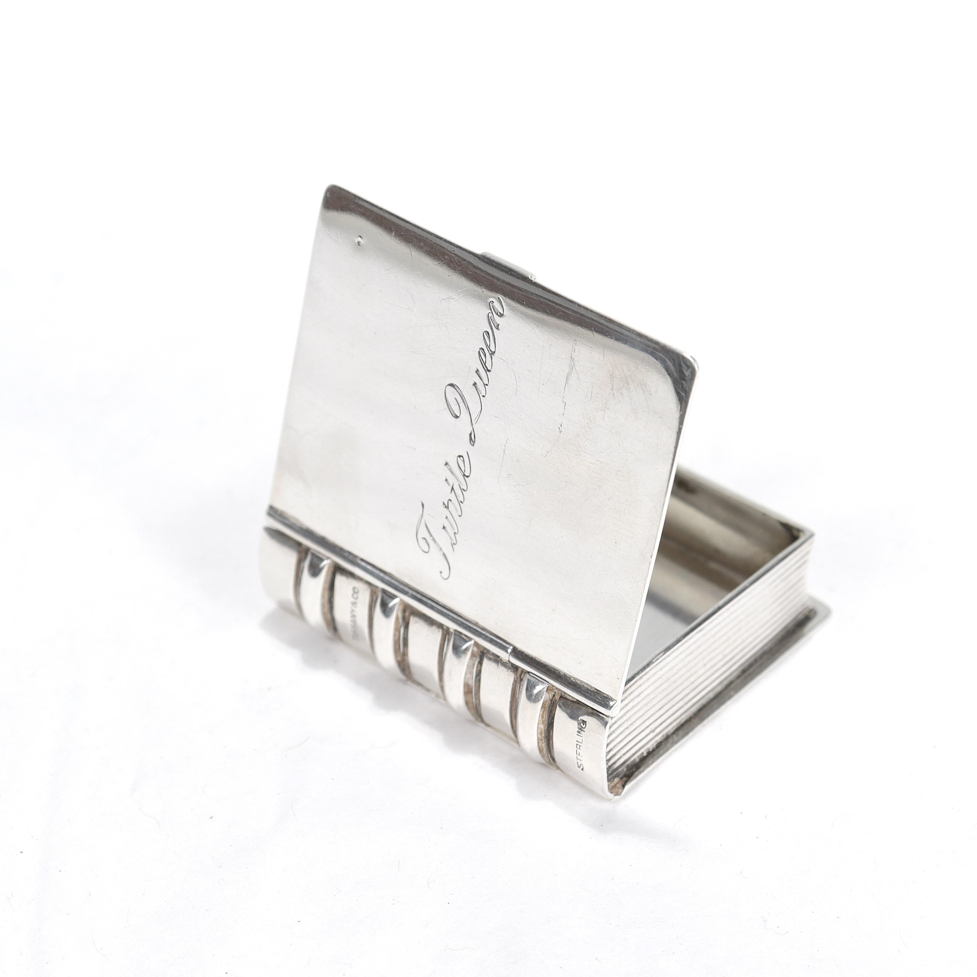 A fine vintage sterling silver pill box.

By Tiffany & Co.

In sterling silver.

In the form of a book.

Engraved with a whimsical 
