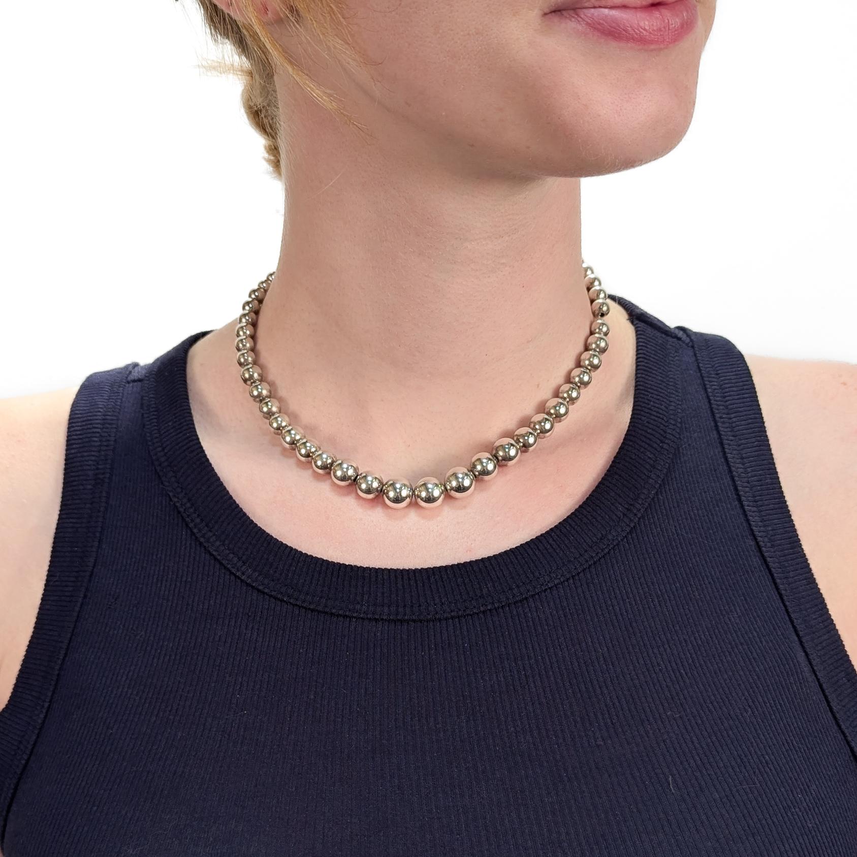 A fine signed silver beaded necklace.

By Tiffany & Co.

In sterling silver.

With graduated beads strung on a silver link chain. 

Measures approx. 16 1/4 in.

Secured with a lobster claw closure.

Together with its original Tiffany pouch. 

Simply