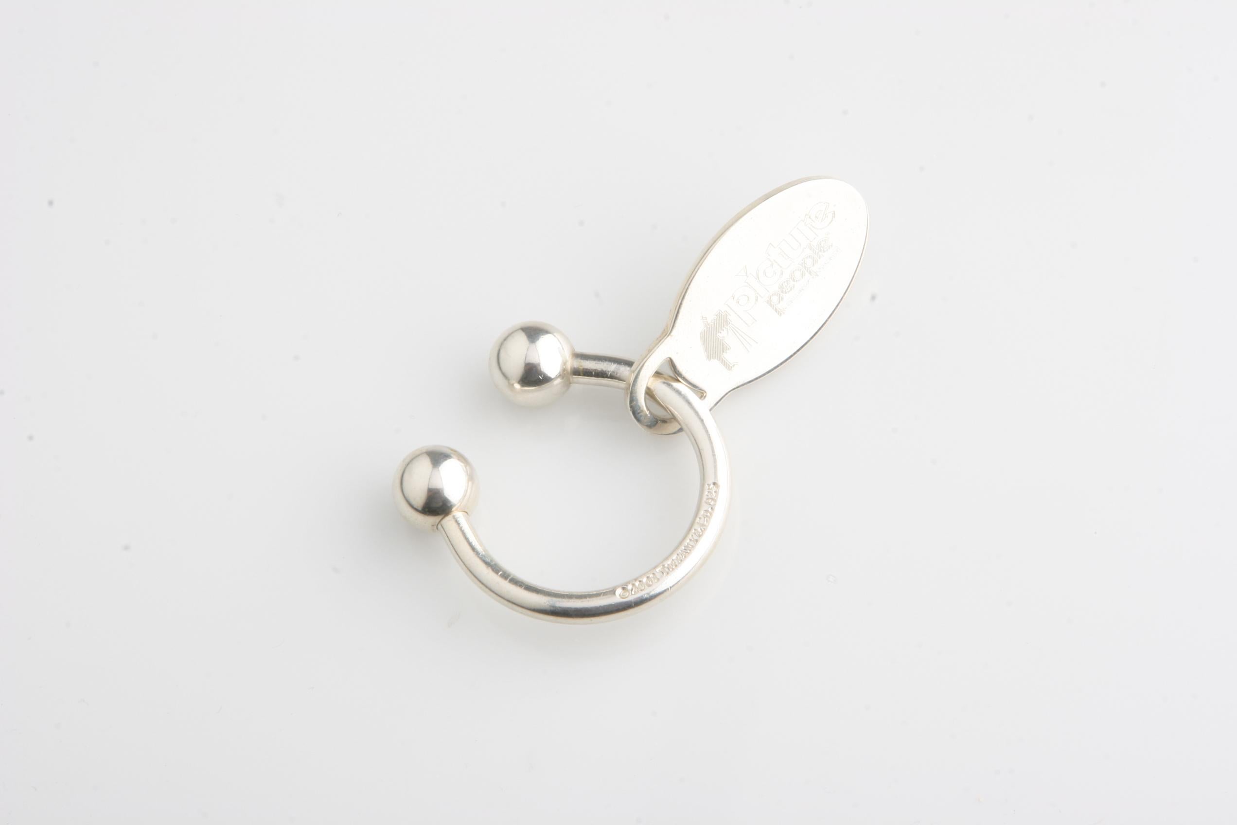 Splendido portachiavi in argento sterling di Tiffany & Co.
Include una targhetta ovale con inciso il logo 