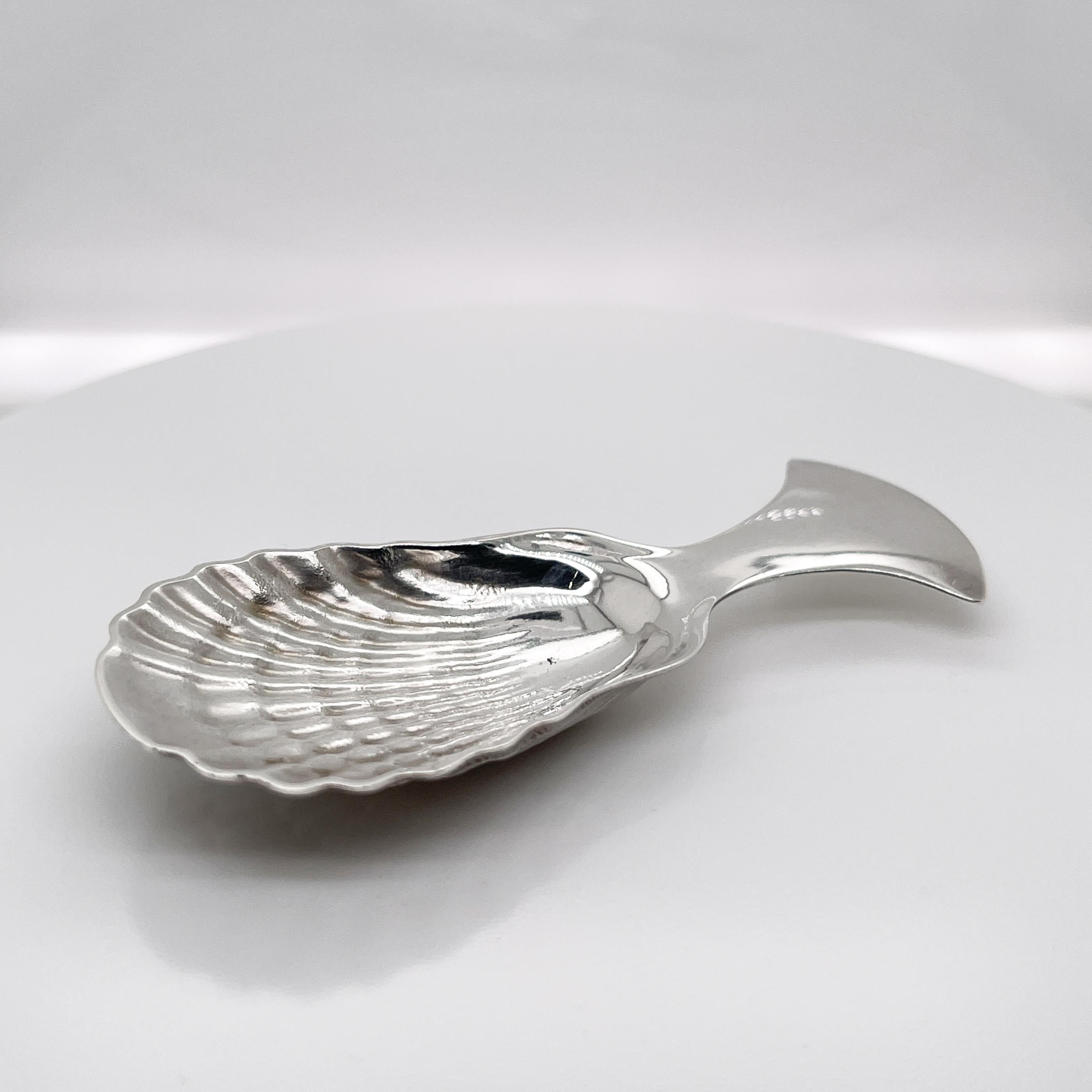 A very fine sterling silver tea caddy spoon.

By Tiffany & Co.

With a scallop shell shaped bowl and a short flared handle. The reverse has raised shell form decoration. 

Simply a wonderful tea accessory from Tiffany & Co.!

Date:
20th