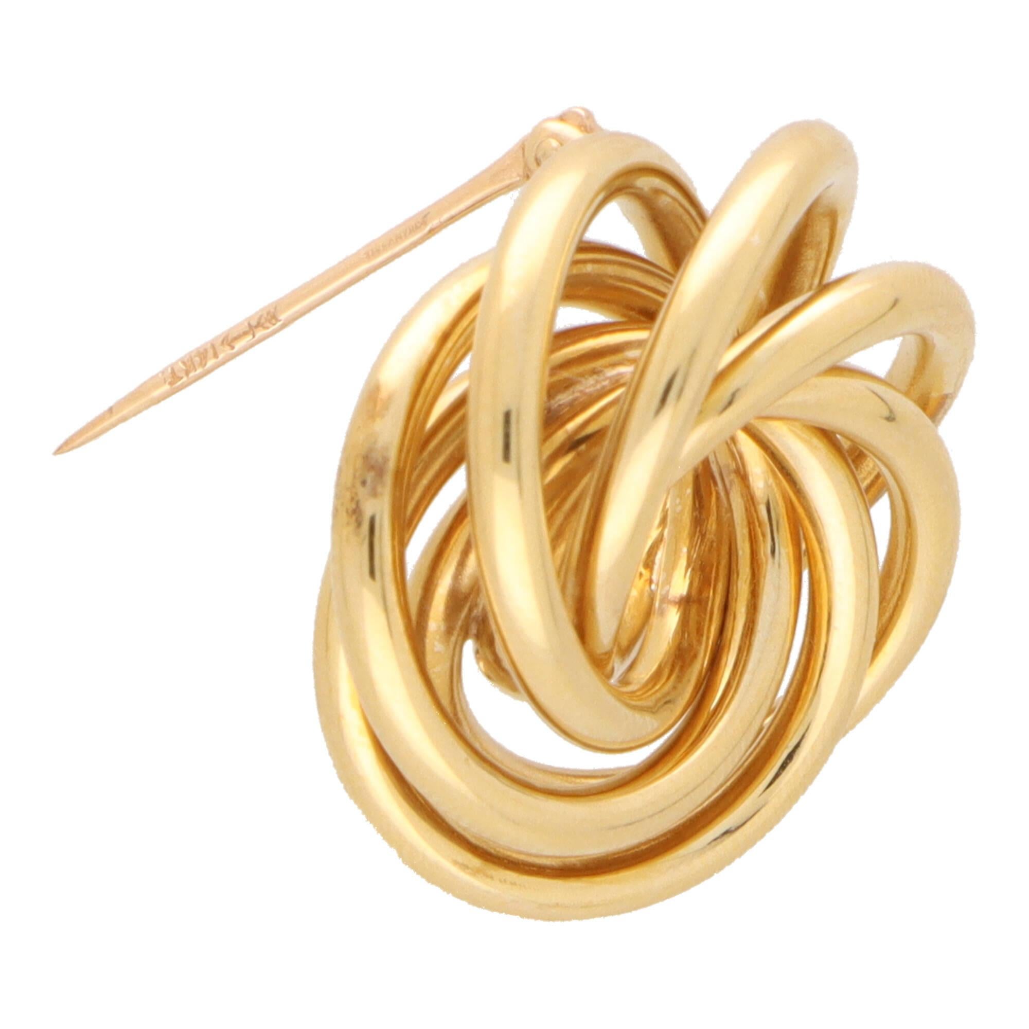 A beautiful vintage Tiffany & Co. swirl brooch set in 14k yellow gold.

The brooch is composed of a number of gold loops intertwined together to create this beautiful swirling optical illusion. It is secured to reverse with a long pin fitting.

Due