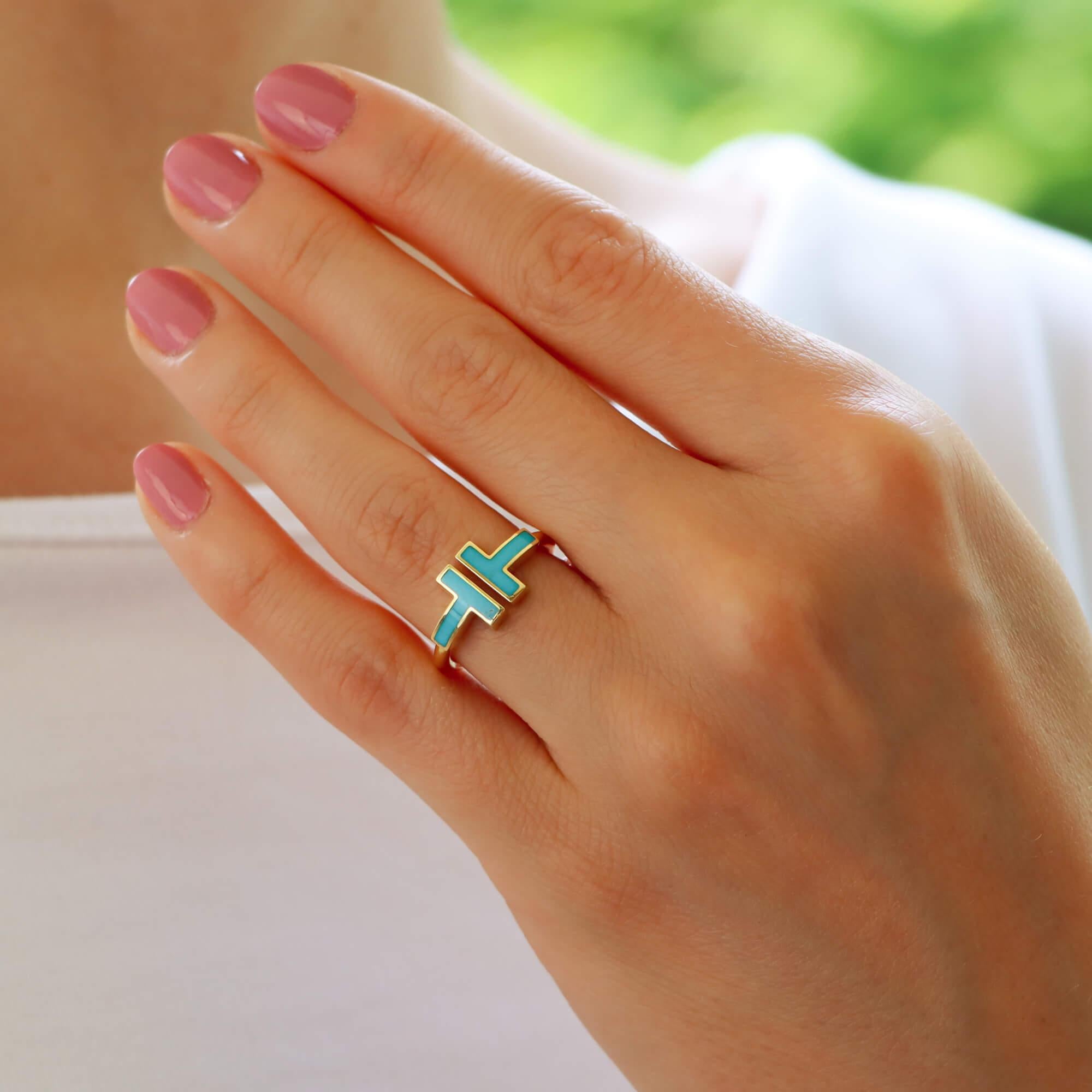 A stylish vintage Tiffany & Co. 'Tiffany T' turquoise ring set in 18k yellow gold.

From the current Tiffany T collection, the ring is set with two carved pieces of natural turquoise in a polished yellow gold band design. The natural formation of