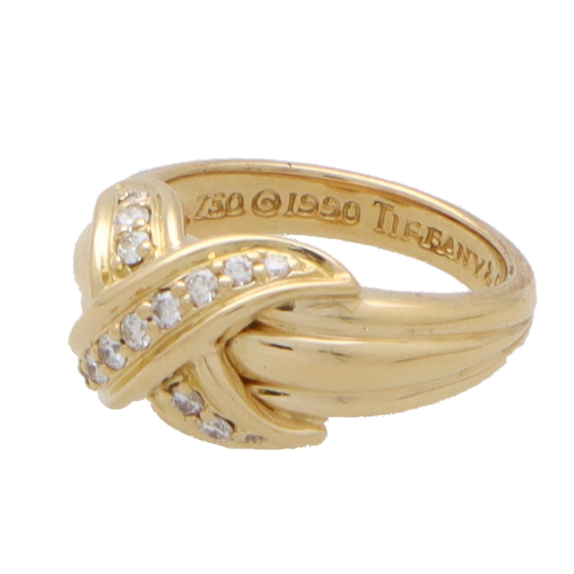 A beautiful vintage Tiffany & Co. signature cross ring in 18k yellow gold.

The ring predominantly features the iconic Tiffany cross motif, set on top of fluted banded shoulders. The cross is pave set throughout with round brilliant cut diamonds.