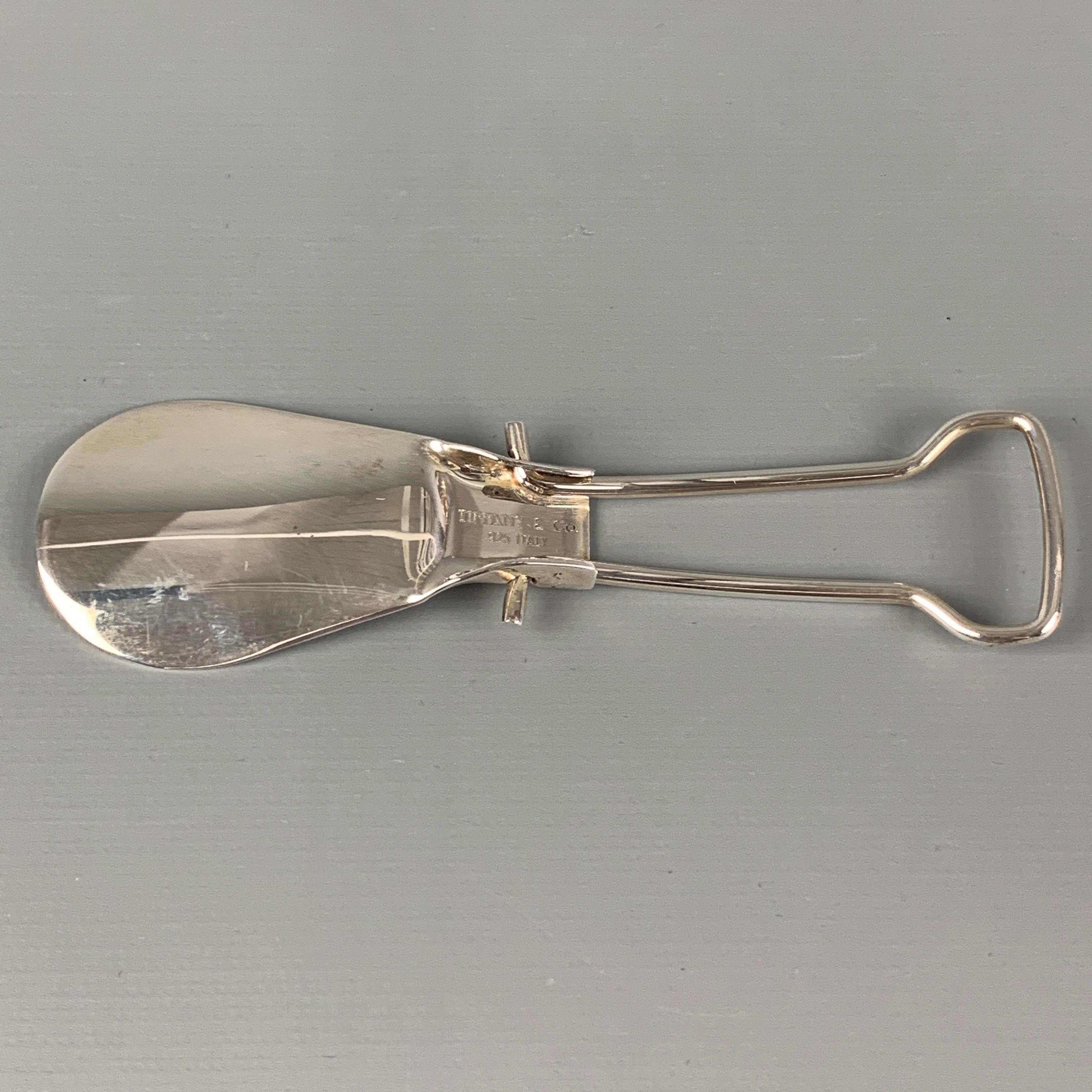 Vintage TIFFANY & CO. folding shoe horn comes in a sterling silver and includes original pouch. 

Very Good Pre-Owned Condition.
Original Retail Price: $320.00

Measurements:

Length: 4.75 in.
Height: 1.5 in. 