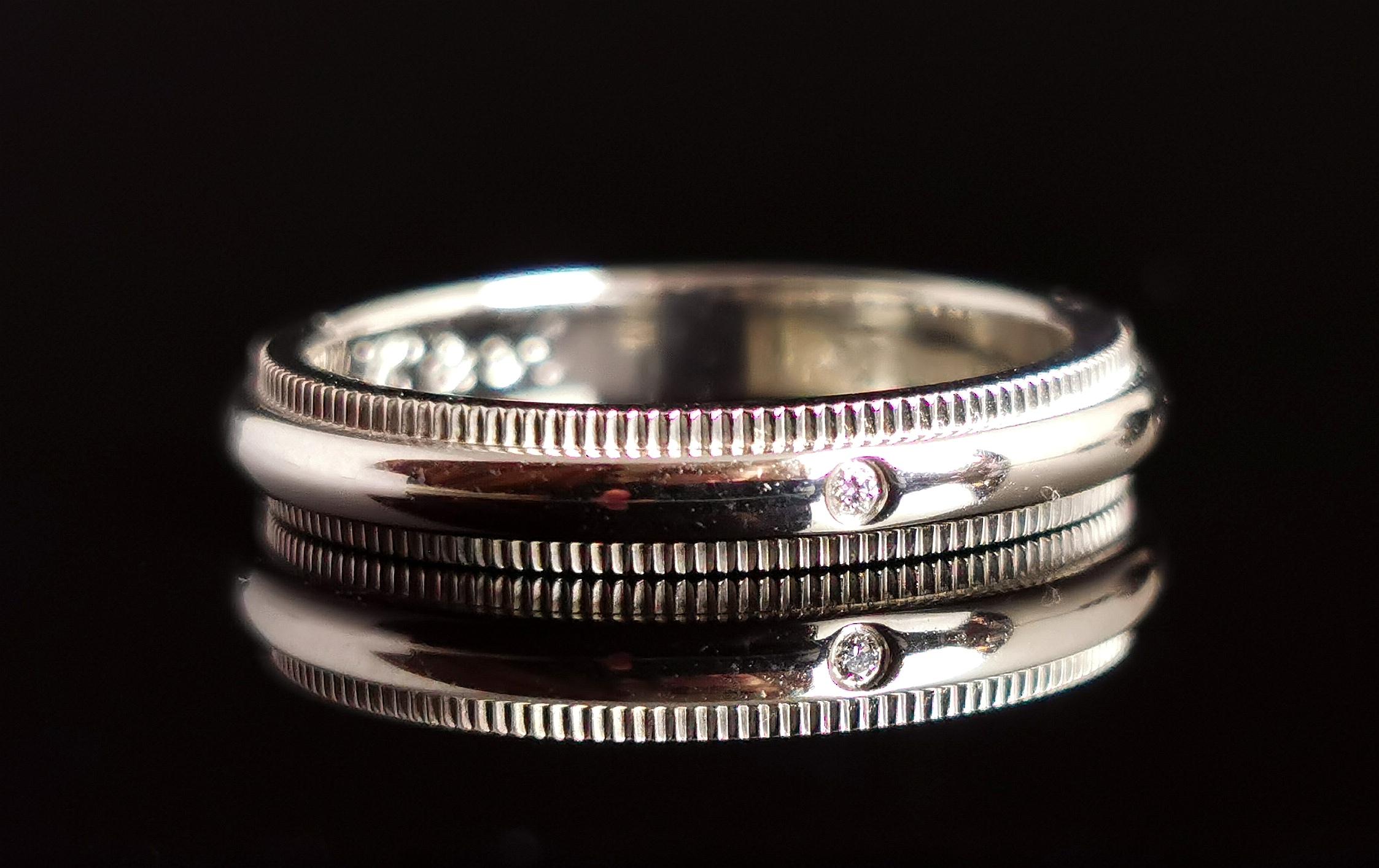 A beautiful vintage Tiffany Classic platinum milgrain band ring.

From the timeless Tiffany classic range, early 2000s, this beautifully crafted ring has a D profile with a millegrain top and bottom edging.

The ring is set with a tiny white diamond