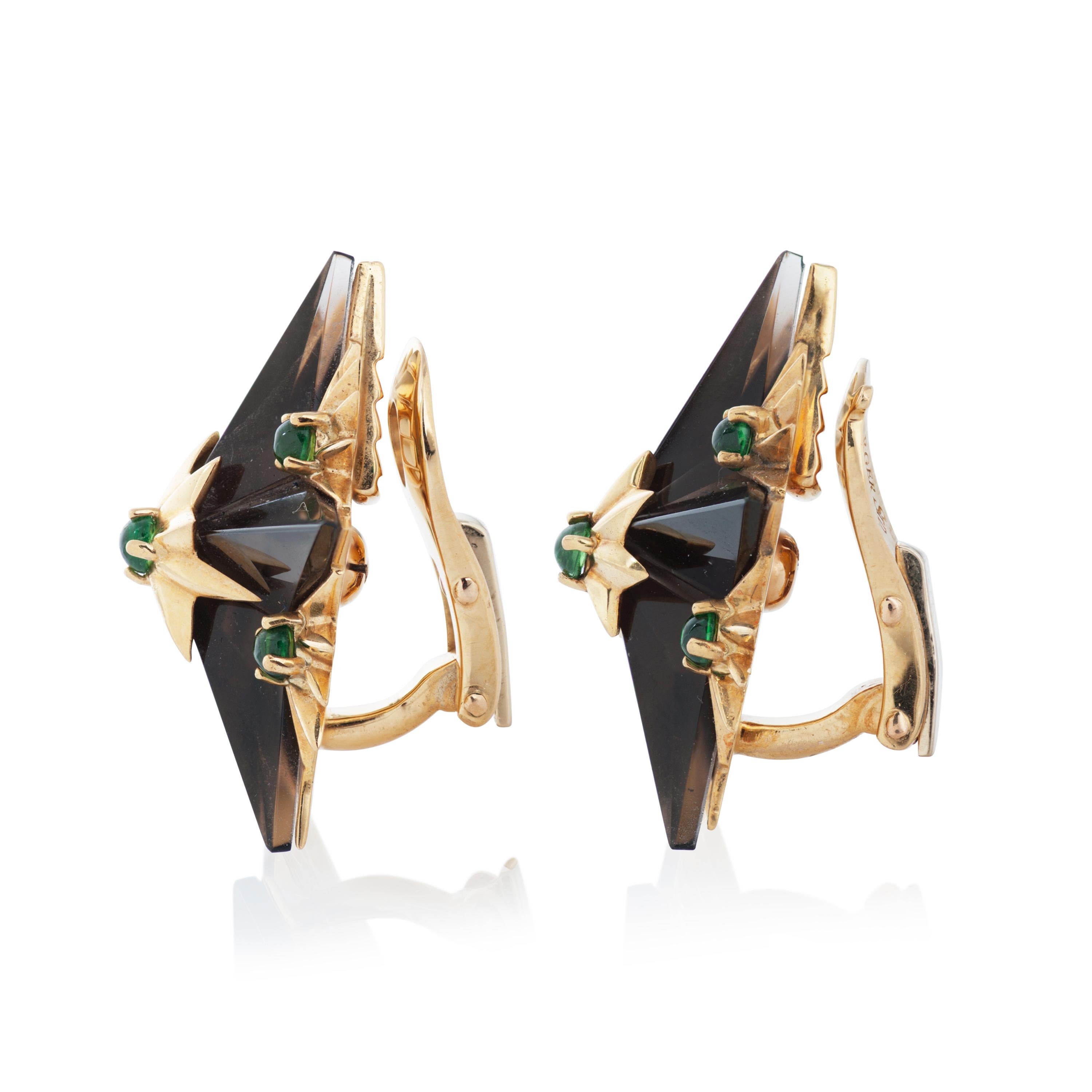 Vintage Tiffany & Co. Schlumberger smoky quartz and green tsavorite garnet starburst clip-on earrings in 18k yellow gold.

This pair of earrings features 2 star shaped smoky quartz accented by 12 round cabochon tsavorite garnets, set in 18k yellow