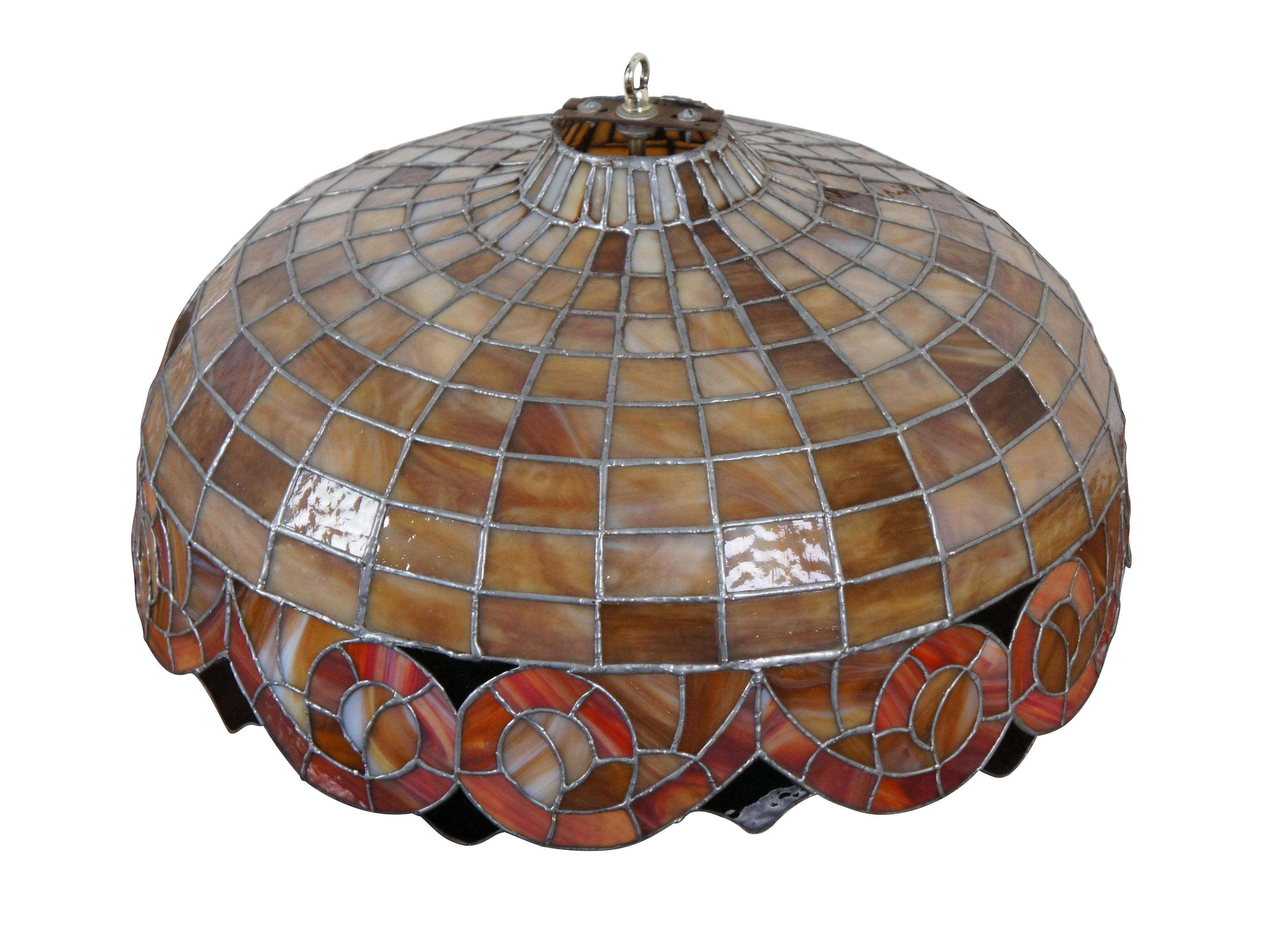 Ein großer und beeindruckender Vintage-Kronleuchter im Tiffany-Stil mit einem Schirm aus gebeiztem Schlackenglas in gestapelten geometrischen und schlangenförmigen Mustern.

Abmessungen:
22