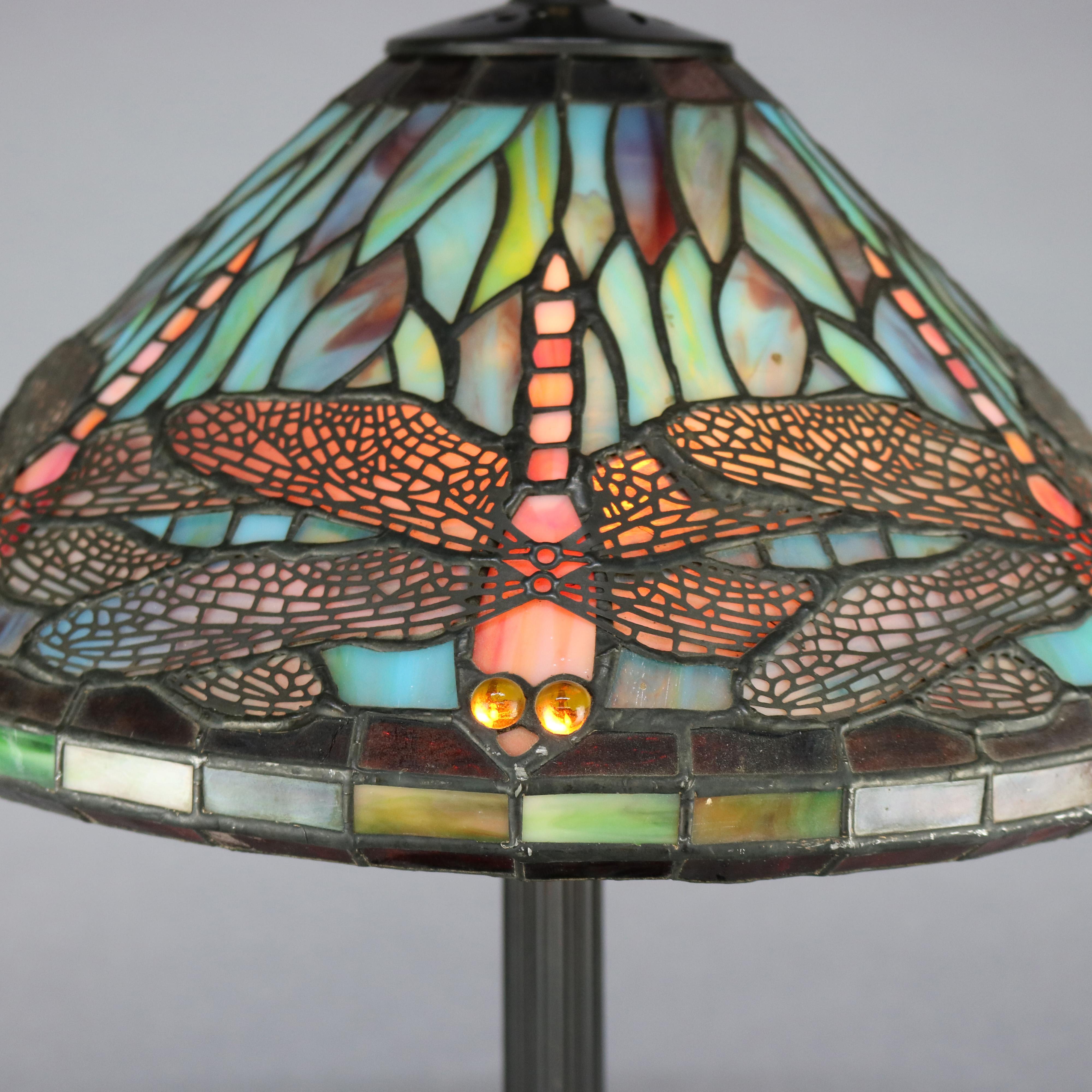 A vintage table lamp in the manner of Tiffany & Co. offers leaded jeweled and slag glass dragonfly design over cast double socket base, 20th century

Measures: 20.25
