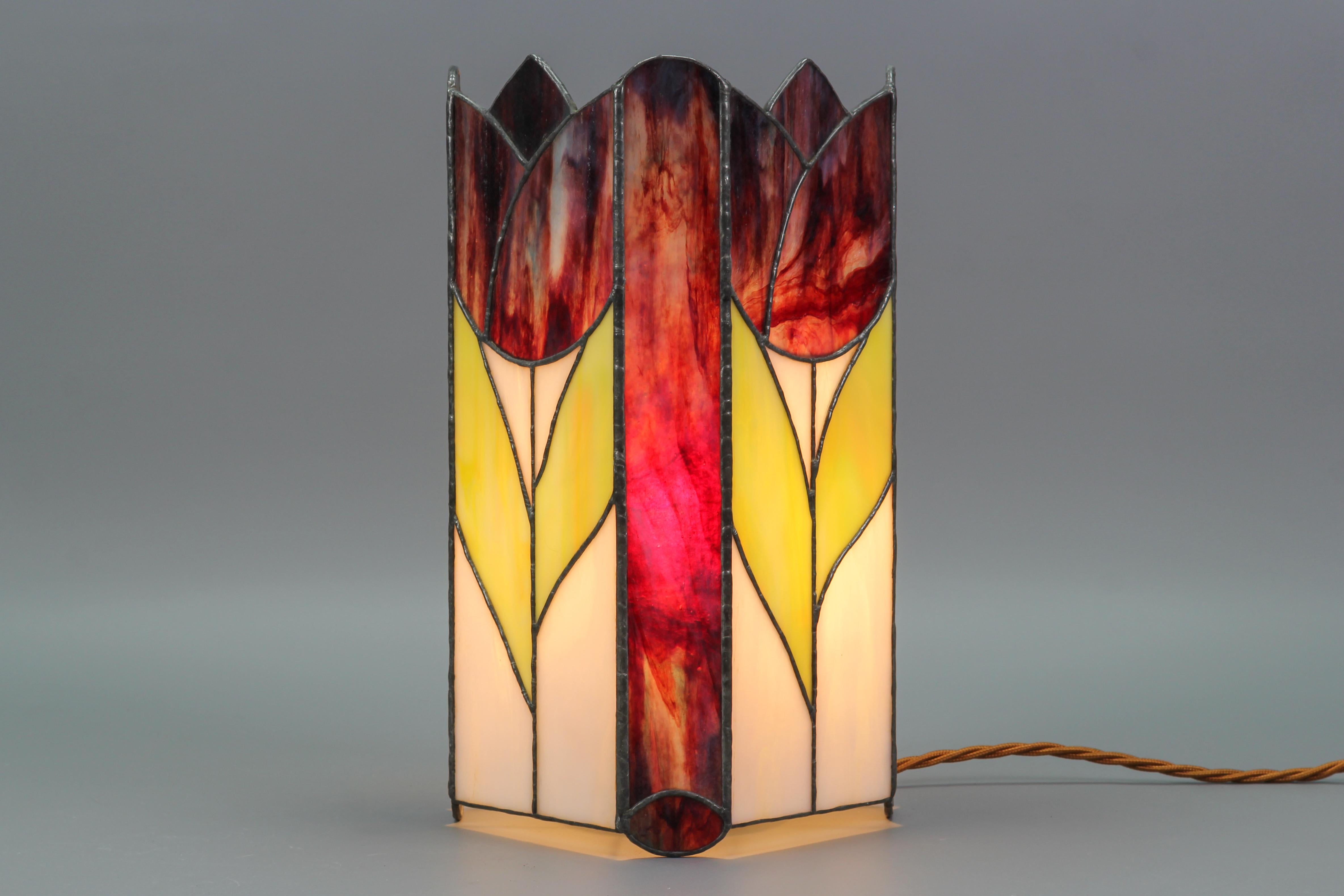 Beautiful vintage Art Nouveau style stained square glass lamp in dark purple and white with tulips in purple and green. The lamp looks wonderful as well as lit as unlit. 
One socket for E27 (E26) light bulb. To the U.S. the lamp will be shipped with