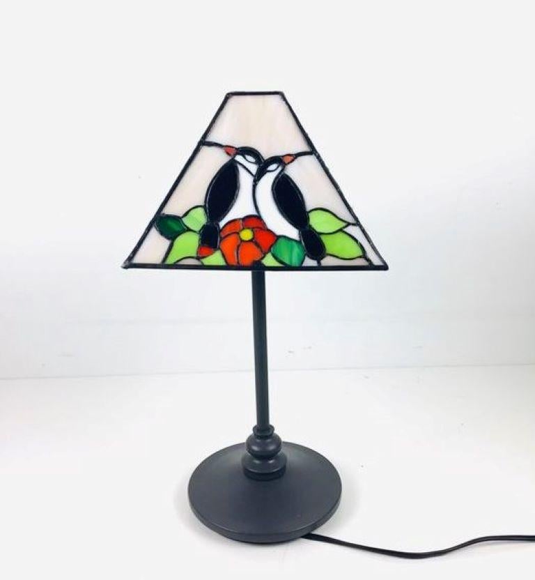 A lovely Tiffany style table lamp with beautiful glass hand-painted shade on a patinated metal base, France 1960s. It takes one large E27 light bulb, providing a warm and pleasant lighting. 
Measures: Height 17.25