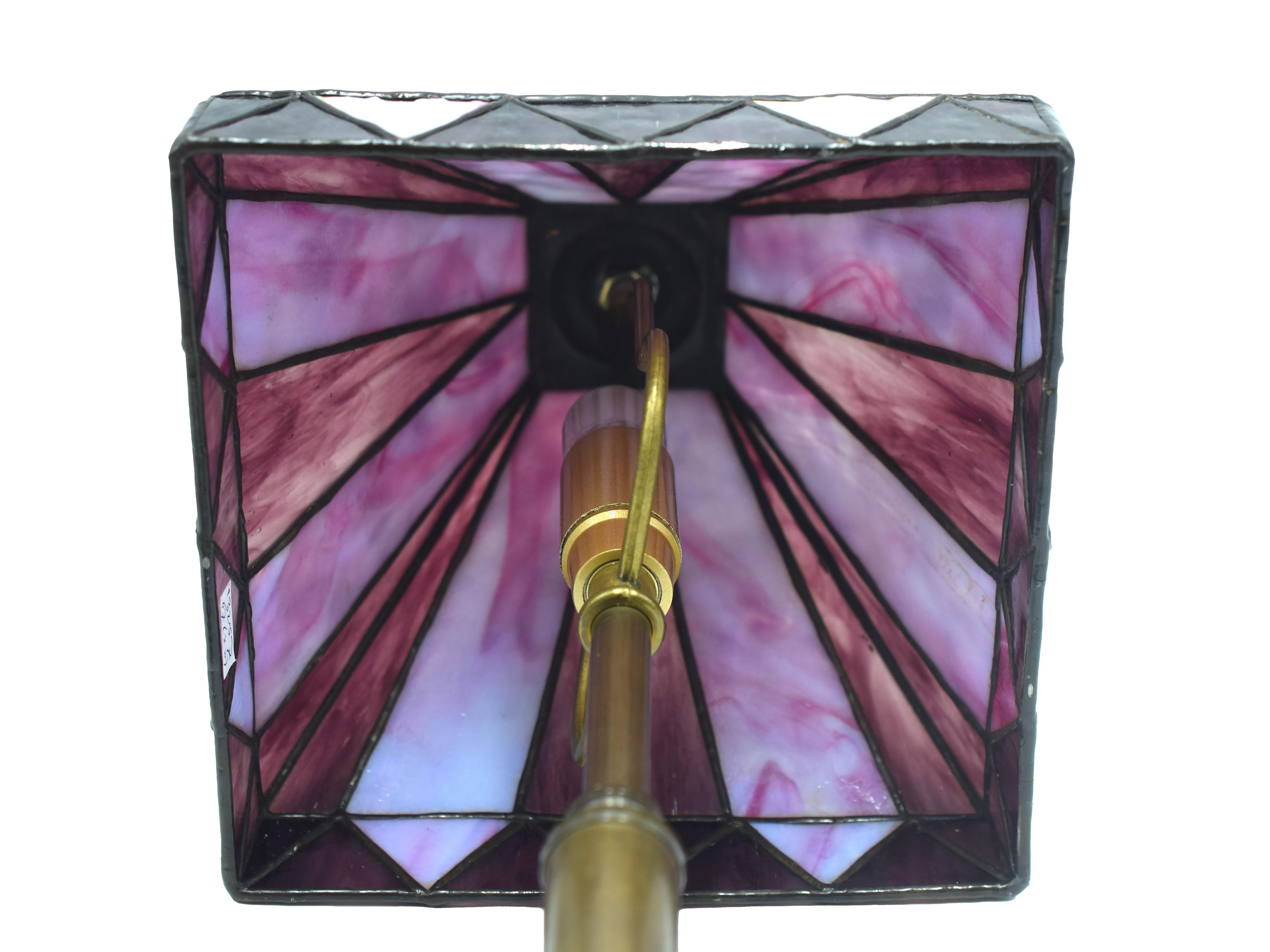 Cette lampe de table de style Tiffany est une élégante lampe design fabriquée au cours de la seconde moitié du XXe siècle, probablement à la fin des années 1950.

Design/One caractérisé par une base en laiton et un superbe abat-jour en violet et