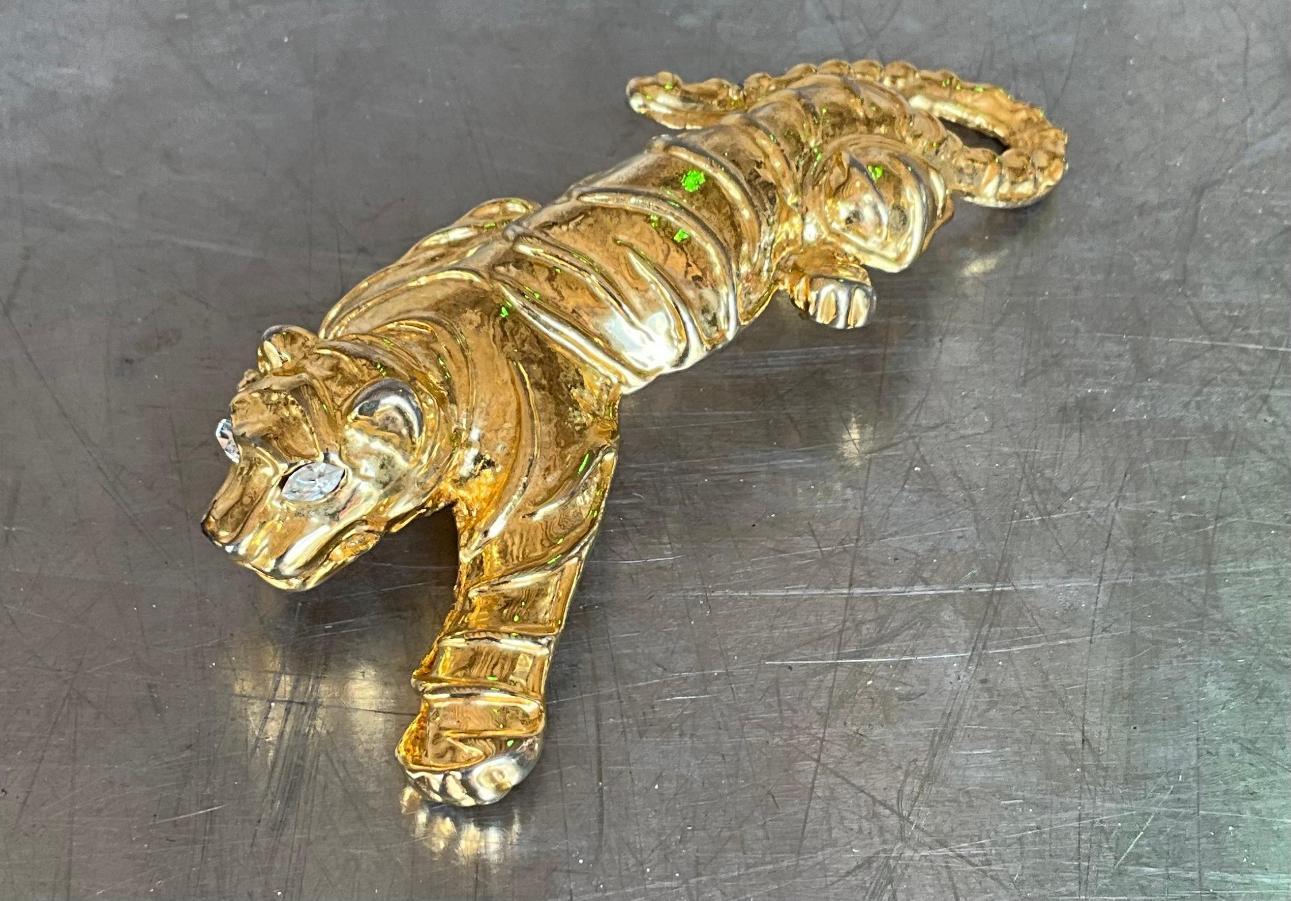 Este impresionante broche de tigre vintage muestra un diseño dinámico y poderoso, que refleja la gracia y la fuerza del tigre. 

El cuerpo del tigre suele acentuarse con un intrincado trabajo de esmalte, lo que permite crear rayas vibrantes en tonos