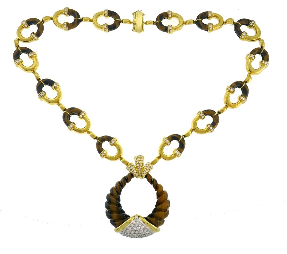 Unusual tribal style necklace, made of 18 karat yellow gold, carved tiger's eye and round brilliant cut diamonds (G-H/VS, 6.00 carats total). Created in the 1970s by MOBA, a jeweler known for high quality brightly colored jewels in the post-WWII