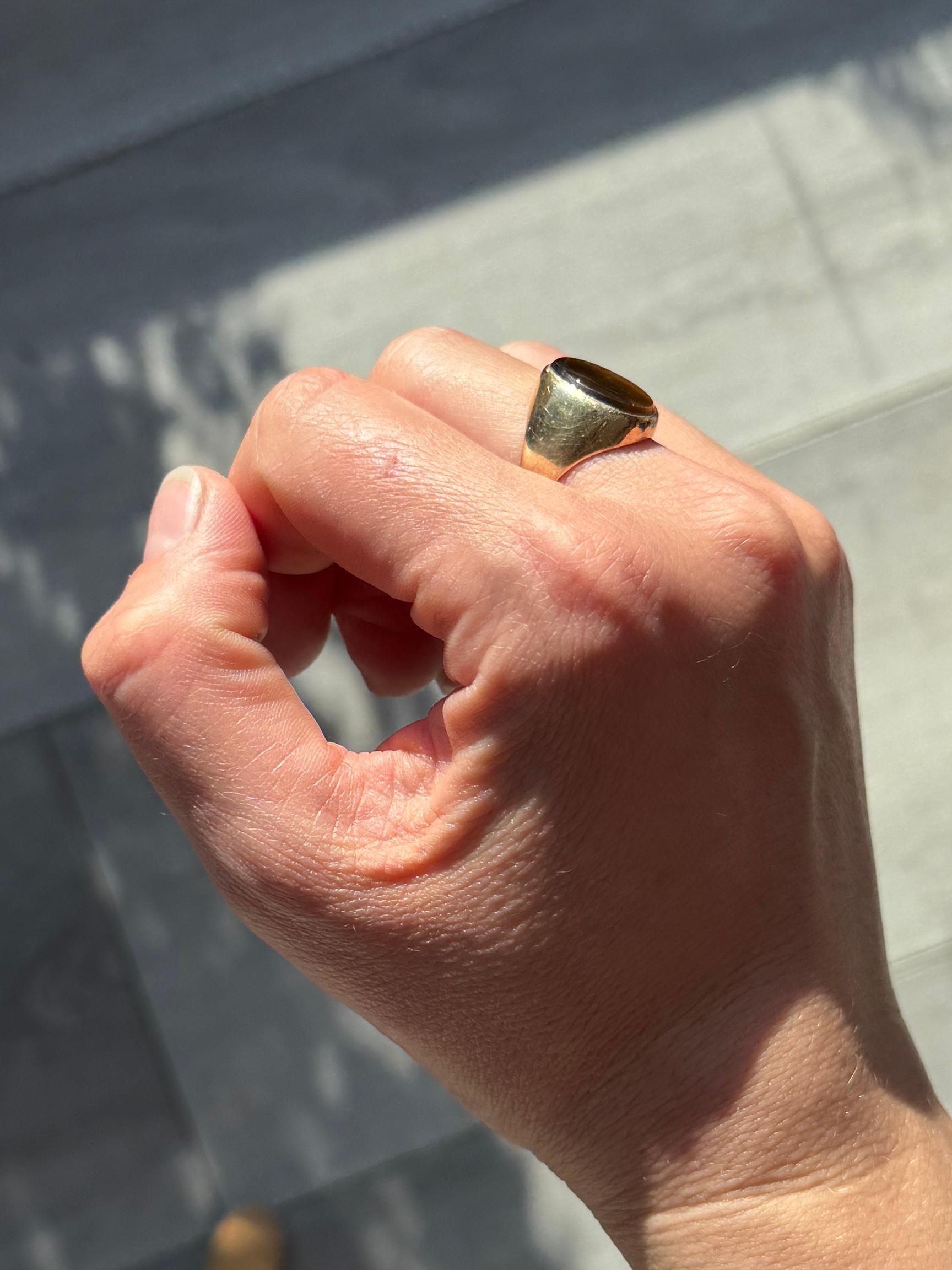 Questa pietra occhio di tigre è davvero affascinante. Il colore è il classico marrone con sottili strisce di marrone più scuro che lo attraversano. La montatura è realizzata in oro 9ct. Marchio Chester 1917.

Dimensioni: I 1/2 o 4 1/2 
Dimensioni