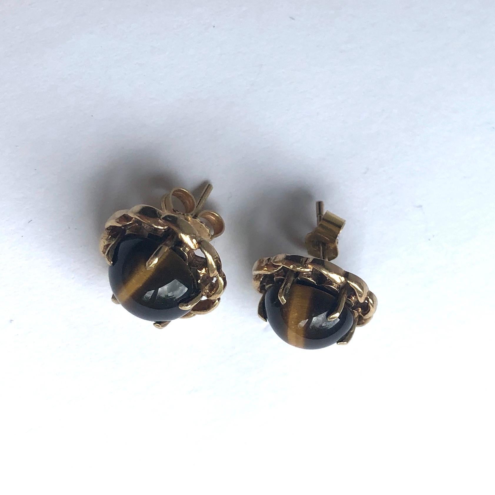 Estas piedras de ojo de tigre son realmente fascinantes. Dieron el clásico color de lazo profundo y la raya de un marrón más claro que lo atraviesa. Los engastes están modelados en oro de 9 ct. 

Diámetro de la cara: 13,5 mm 
Altura fuera de la
