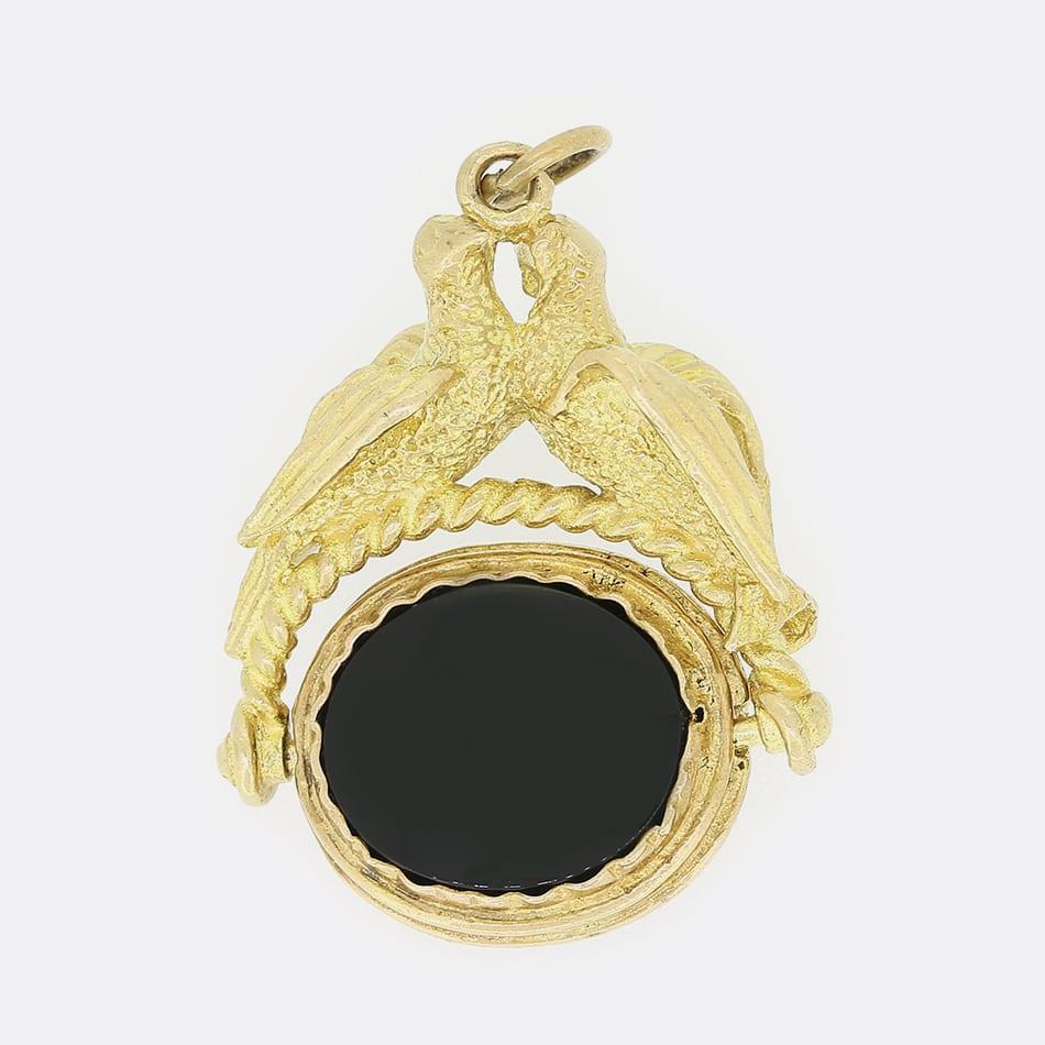 This is a vintage 9ct yellow gold swivel fob. One side of the fob is set with an onyx and the other is set with a tigers eye. The fob also features two birds which are entwined.

Condition: Used (Very Good)
Weight: 7.8 grams
Pendant Dimensions: 33mm