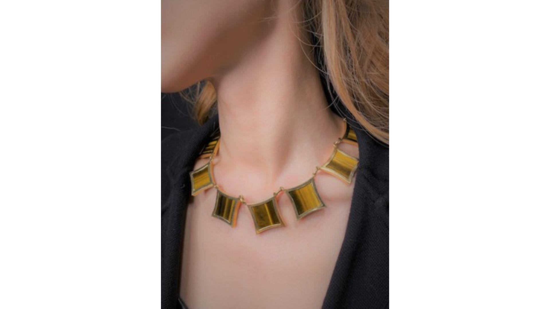 Collana in quarzo occhio di tigre e oro 18 carati di G. Vascellari. 

La parte anteriore sospende otto tavolette di quarzo occhio di tigre, completate da una catena a cordoncino in oro massiccio, firmata dall'importante designer G. Vascellari. La