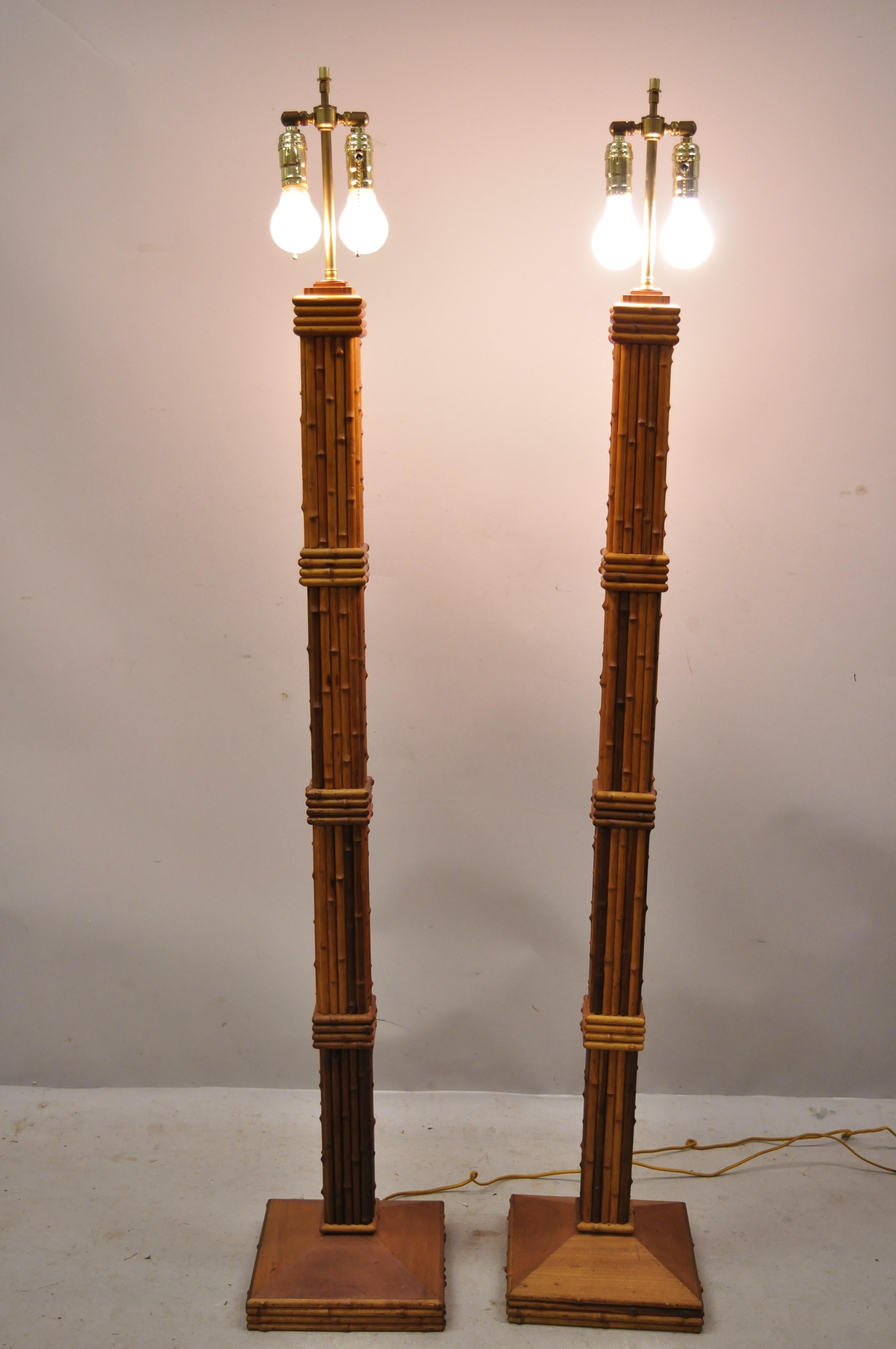 Vintage Tiki Rattan Hollywood Regency wood faux bamboo floor lamps - a pair. Item features double light sockets, adjustable height brass harp rods, carved wood faux bamboo frames, solid wood frame, beautiful wood grain, very nice vintage pair, great