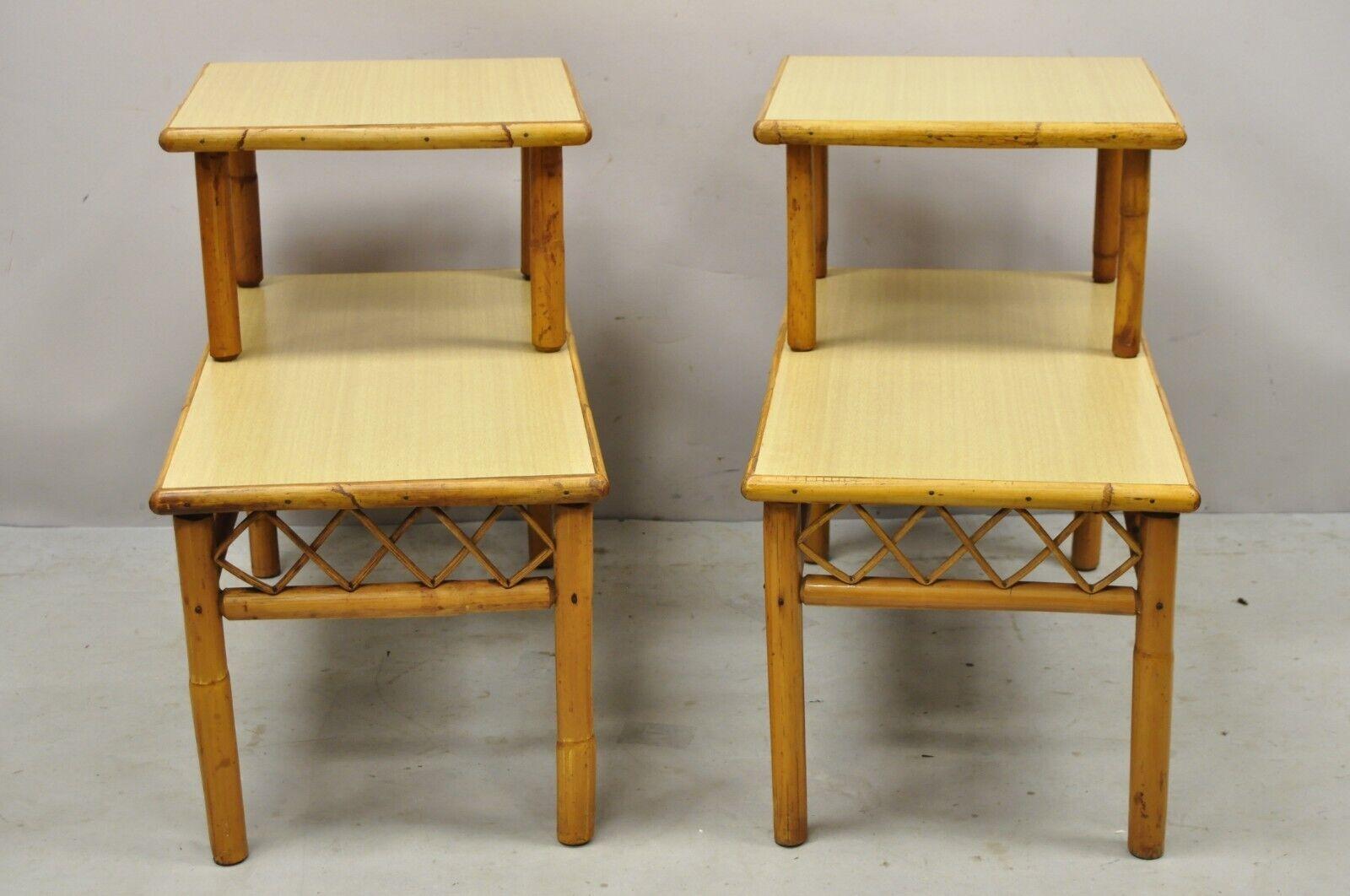 Vintage tiki rattan mid century bamboo step up end tables - a pair. Item featured has 2 tiers, bamboo wood frame, laminate surfaces, very nice vintage set, clean modernist lines, great style and form. circa Mid-20th Century. Measurements: 23.5