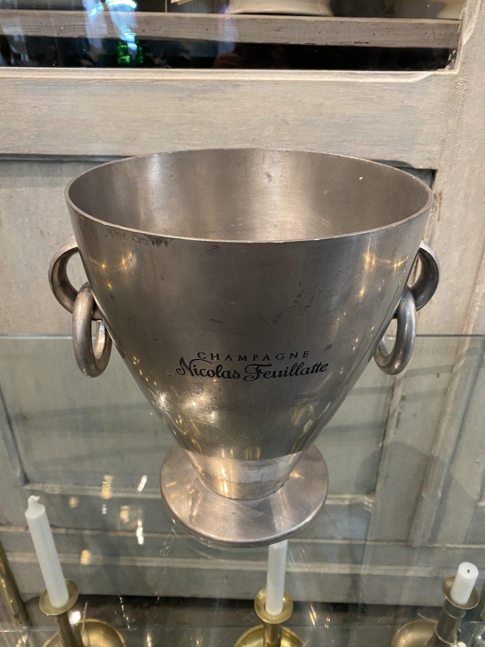 Impressive handsome vintage French champagne cooler, in patinated matte tin, and designed as a cup. Fabulous shape, with two stylish side handles. Designed for one magnum bottle but can hold 2 standard bottles.

Champagne Nicolas Feuillatte is the