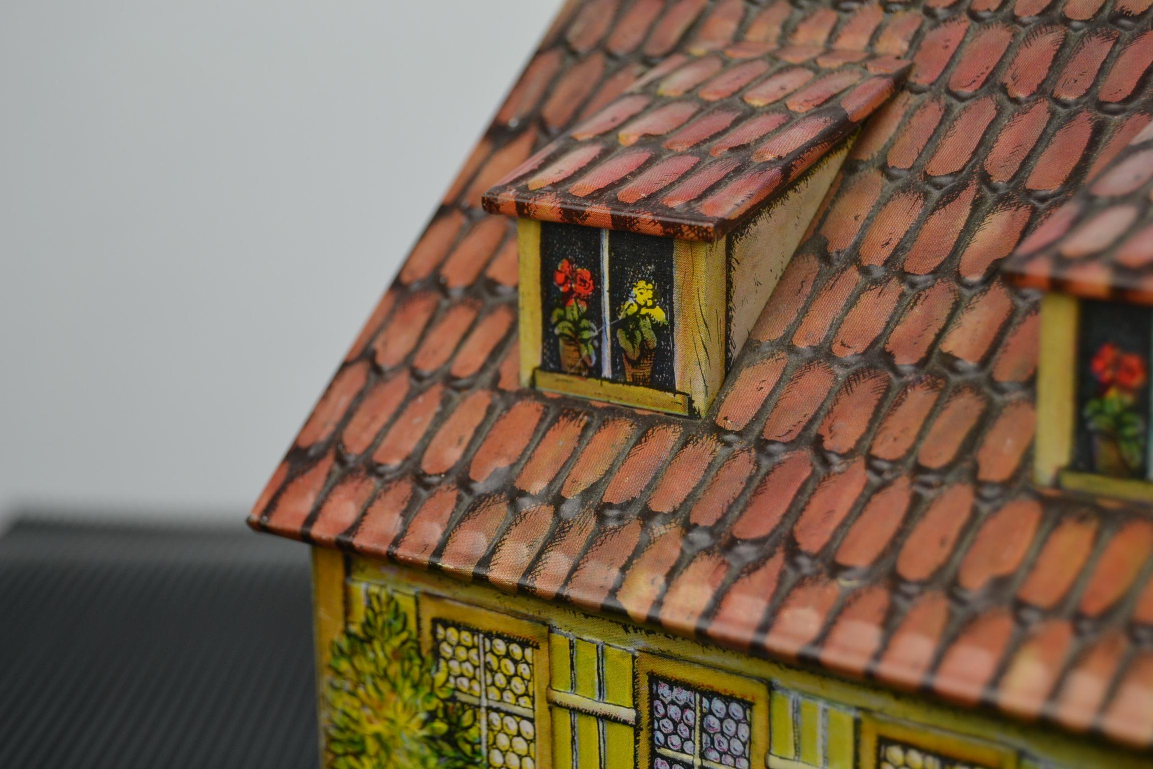 Adorable vintage chocolate, cookie, gingerbread tin storage box.
This Figural tin, in the shape of a house, was produced in the 1980s in W- Germany for Heinrich Haeberlein Nuremberg, producer of ginger cookies and chocolate. 

This Tin House has