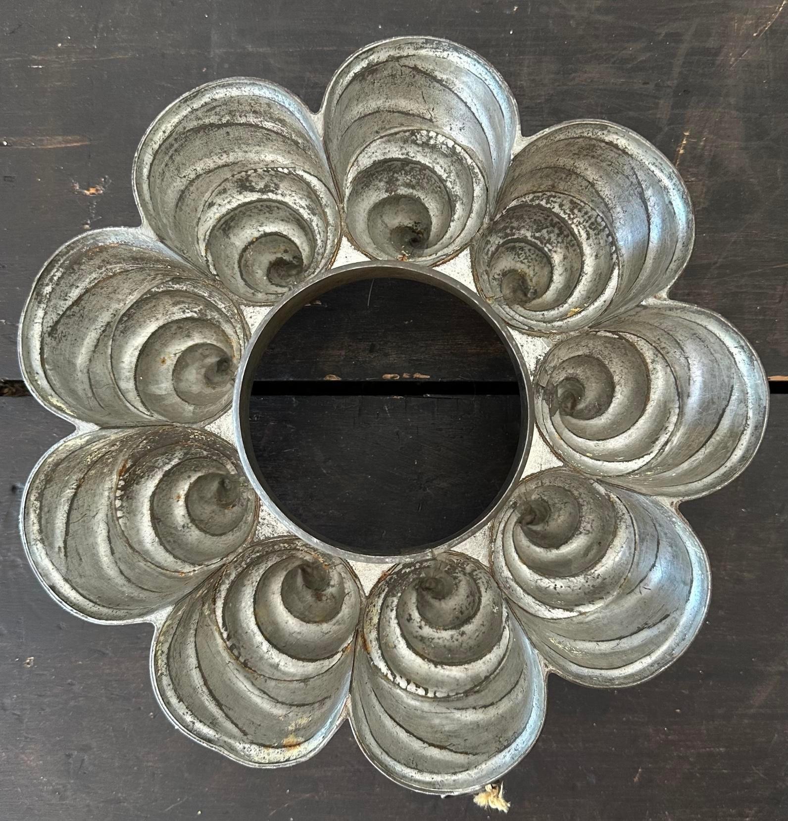 Ajoutez une touche nostalgique à votre cuisine avec ce moule à aliments en forme de tourbillon en étain vintage. Parfait pour la cuisson ou comme charmante pièce décorative, son design unique en forme de tourbillon apporte une touche d'élégance