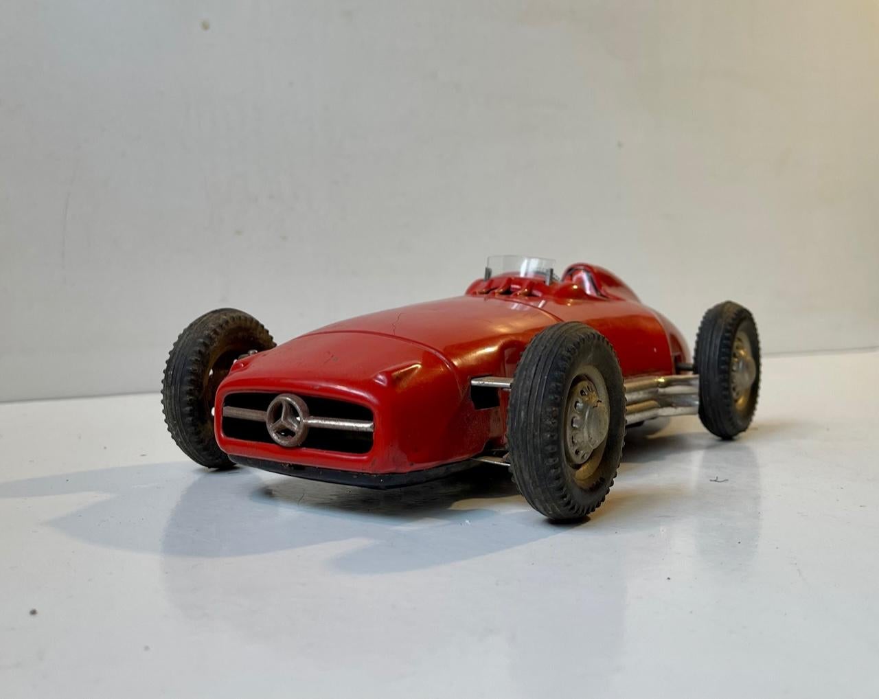 This Mercedes Benz racer was made by JNF in Western Germany in the 1950’s. It’s a tin friction operated toy, and its 33 cm/13.25? long. It features: Pressed tin carcass, Red original lacquer (more rare than the grey version), Black rubber tires the