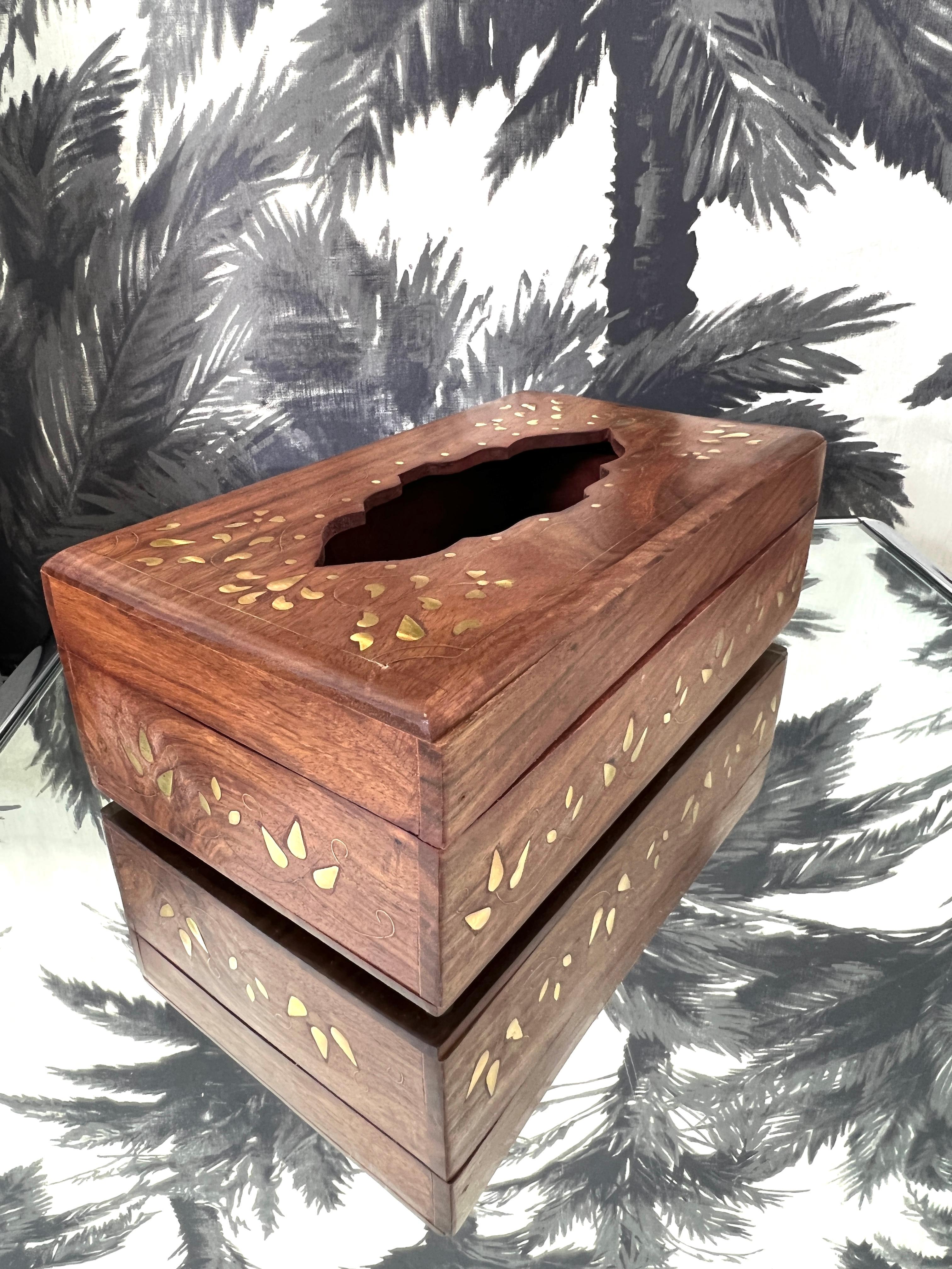 Exquise boîte à mouchoirs vintage en bois de sheesham massif avec incrustations de laiton exotique. Fabriquée à la main par des artisans indiens, la boîte présente un centre stylisé sculpté à la main avec des incrustations géométriques de feuillage,