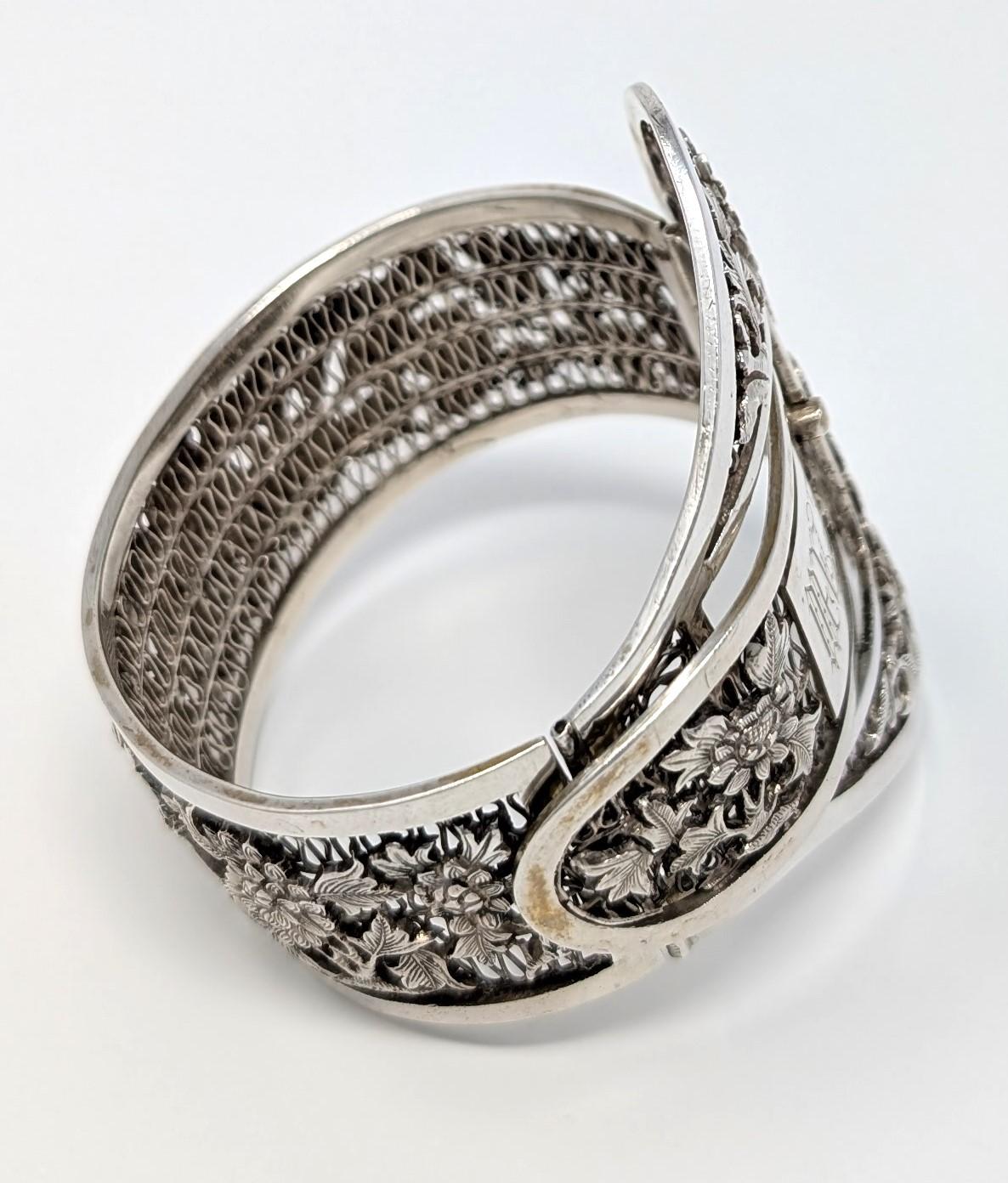 Superbe bracelet boucle ancienne en argent sterling de l'Indochine française avec un motif filigrané. Il est orné d'un motif floral et du monogramme MVZ au centre. Une magnifique pièce d'apparat mesurant 2,75 pouces à ses points les plus hauts par