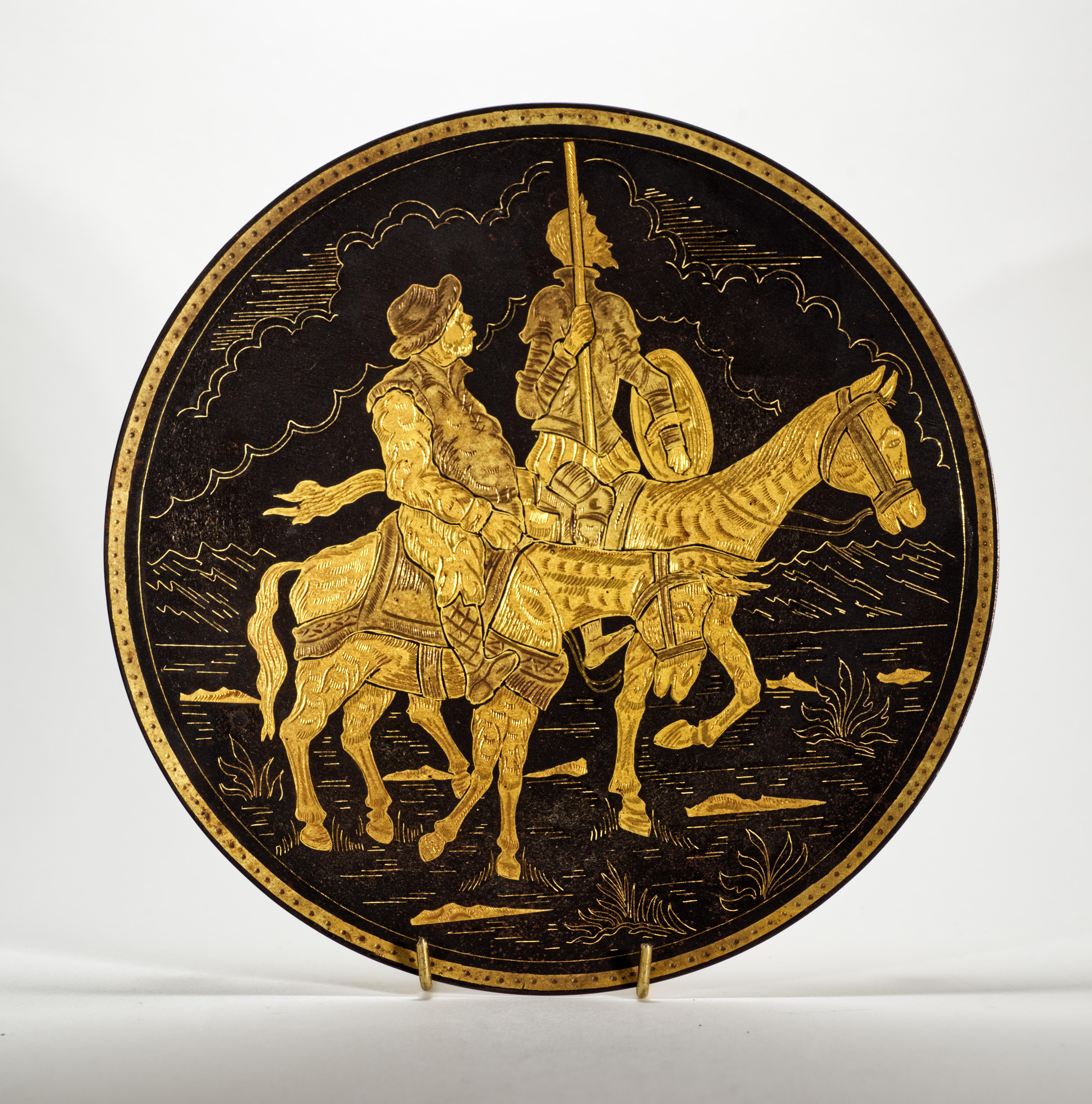  Vintage damascene plate was hand crafted in the metal art studios in Toledo, Spain. It is decorated with the iconic characters of Don Quixote and Sancho Panza in gold on matte black background; the center of the plate portrays a scene from the book