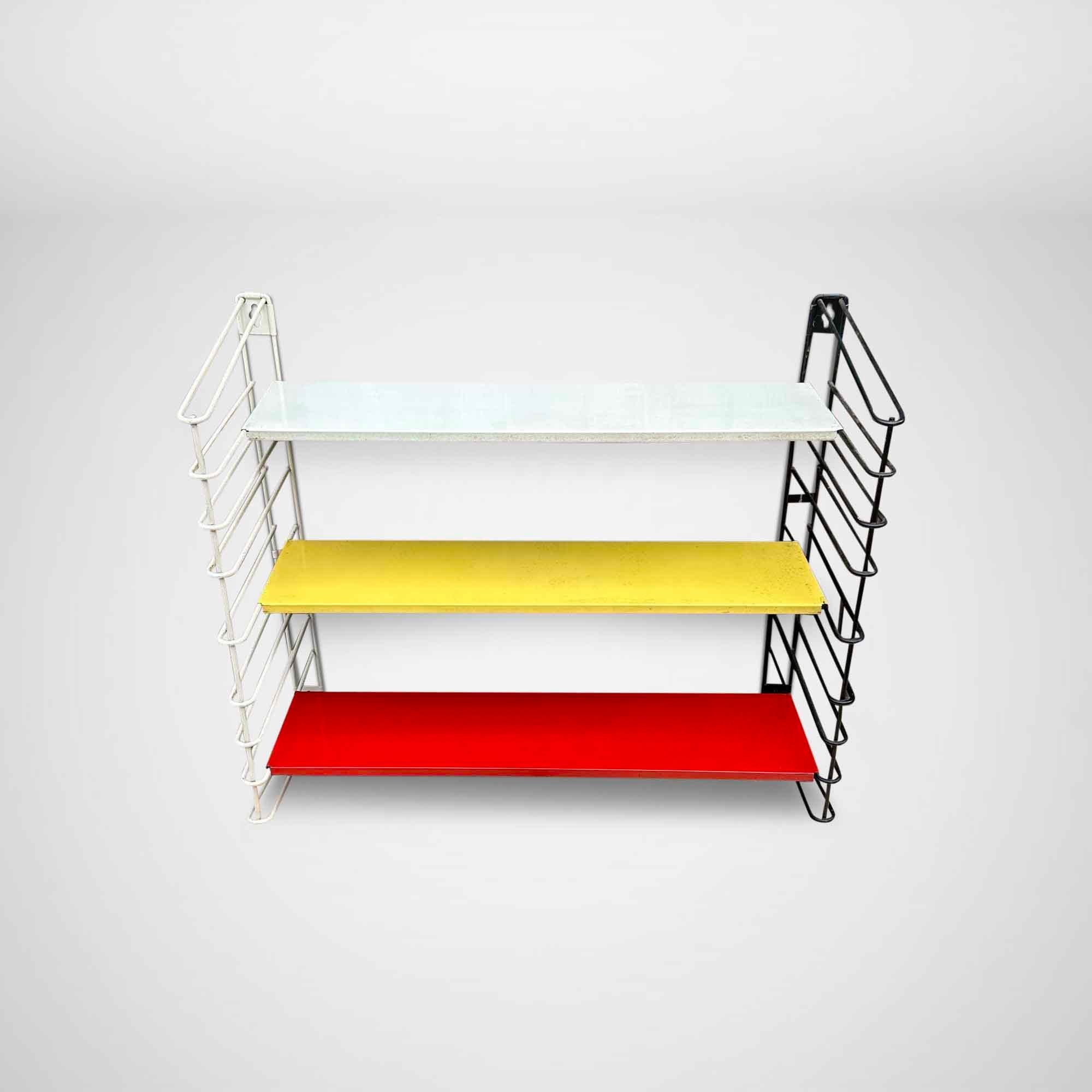 Beautiful mid-century wall rack by Adriaan Dekker for Tomado. The shelves are white, red, and yellow. The string shelves are black and white. This is a smaller model than most other Tomado wall units. The rack shows wear & tear (see