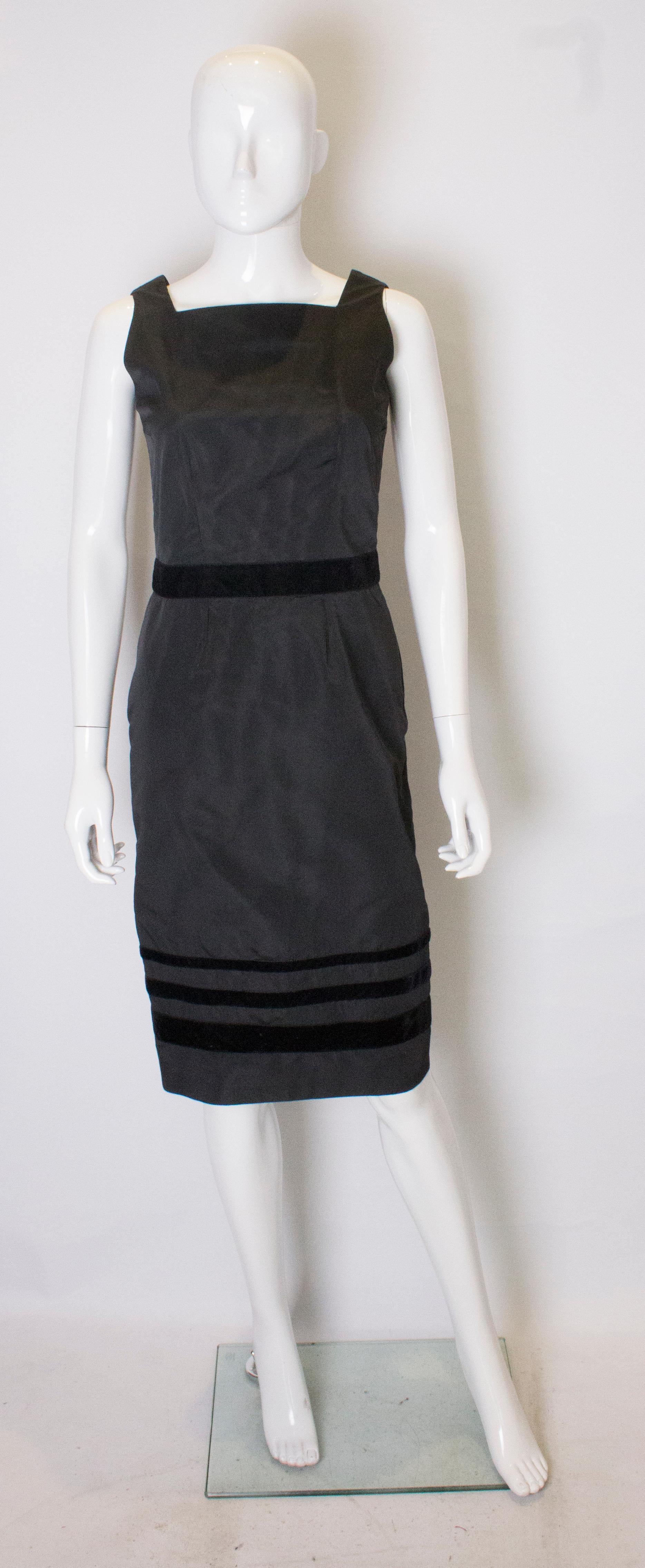 A chic cocktail dress from Tomasz Starzewski. The dress has velvet detail at the waist and hem, has a central back zip and is fully lined.