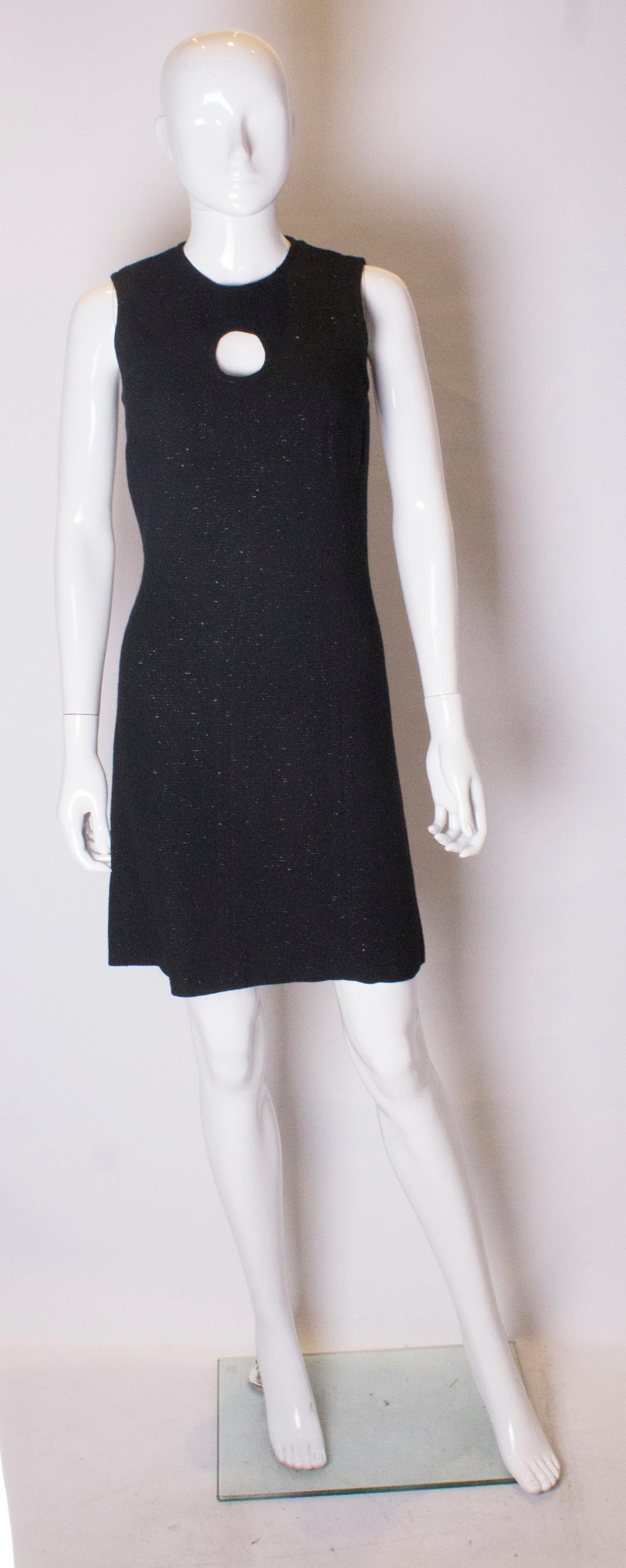 A chic party dress by Tomasz Starzewski. In a black wool with silver thread detail , this dress is a real head turner. It is beautifully cut and has a central back zip and keyhole detail at the front.