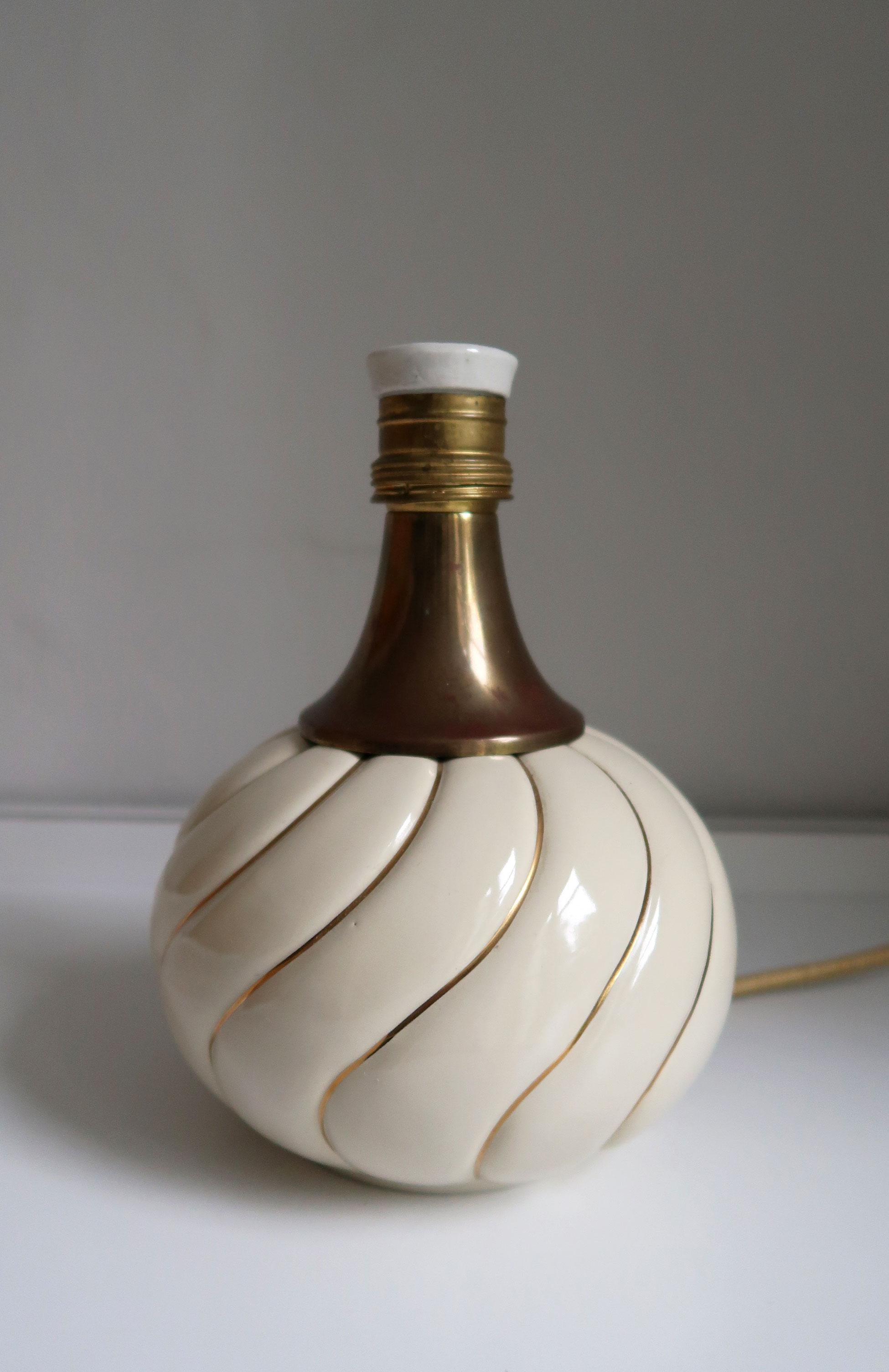 Curvy vintage Tommaso Barbi style table lamp. Ceramic cream colored lamp base with golden striped spiral pattern. Brass top and porcelain fitting. Rewired with golden fabric covered cord. In beautiful vintage condition.