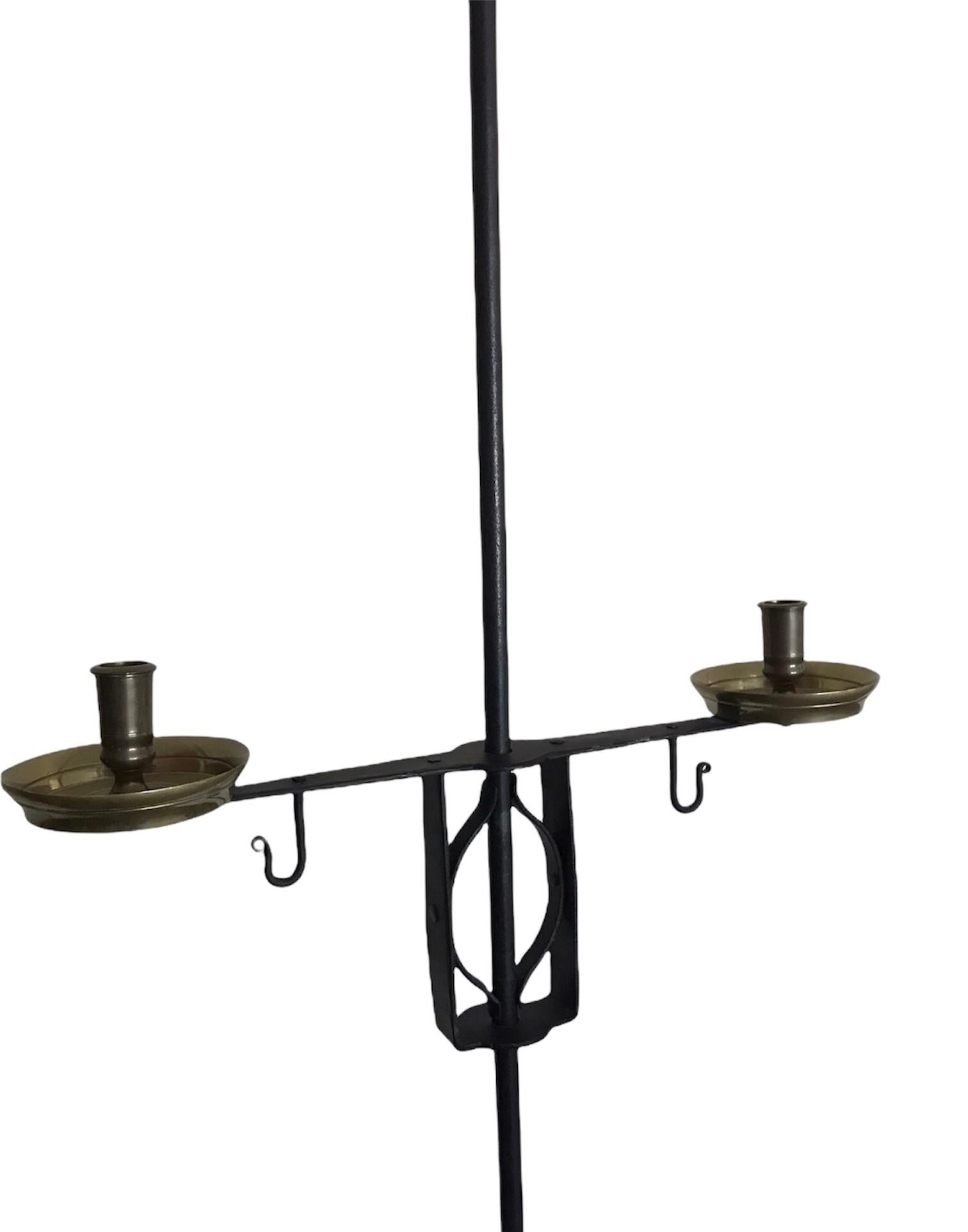 The craftsmanship of forging is remarkable on this black iron with brass accents candelabra. Tall in stature offering two brass candle holders with 3 ribbon-like iron curved legs. Mid Century Designer Tommi Parzinger was noted for his “high-style
