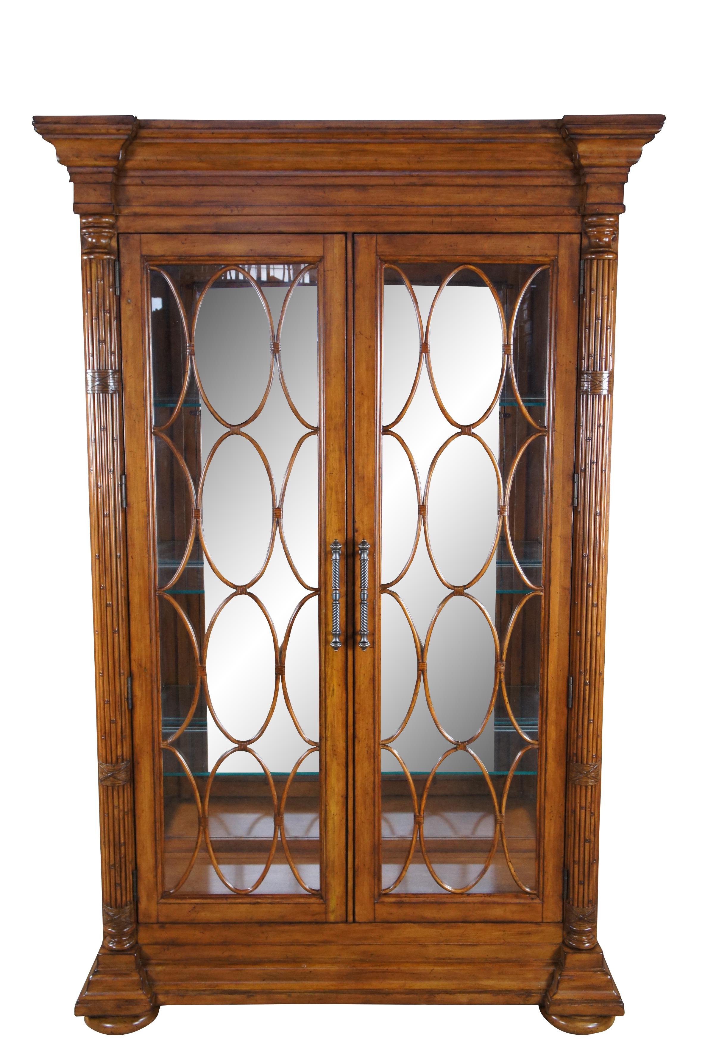 Vintage Tommy Bahama Maple Island Estate Mariana display curio china cabinet featuring decorative bamboo and rattan fretwork with six adjustable glass shelves, mirrored back, and lighted interior.

Dimensions:
86.5
