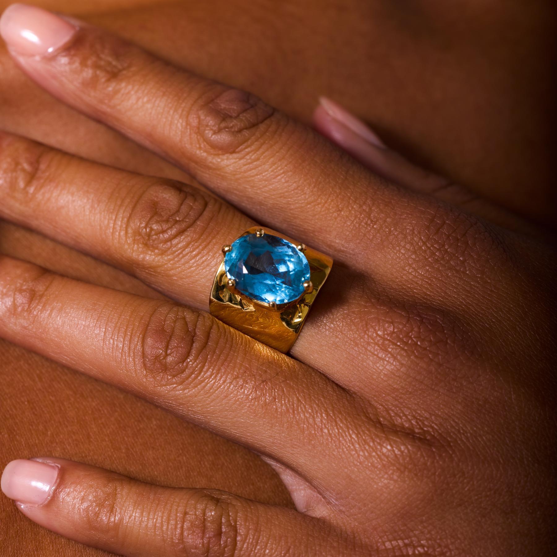 Dieser auffällige und raffinierte Vintage-Cocktailring aus den 1970er Jahren zeigt einen lebhaften Topas mit 10,00 Karat im Ovalschliff, der mit brillantem, goldenem Feuer leuchtet. Die ausgedehnten Facetten des Steins fangen das Licht wunderbar ein