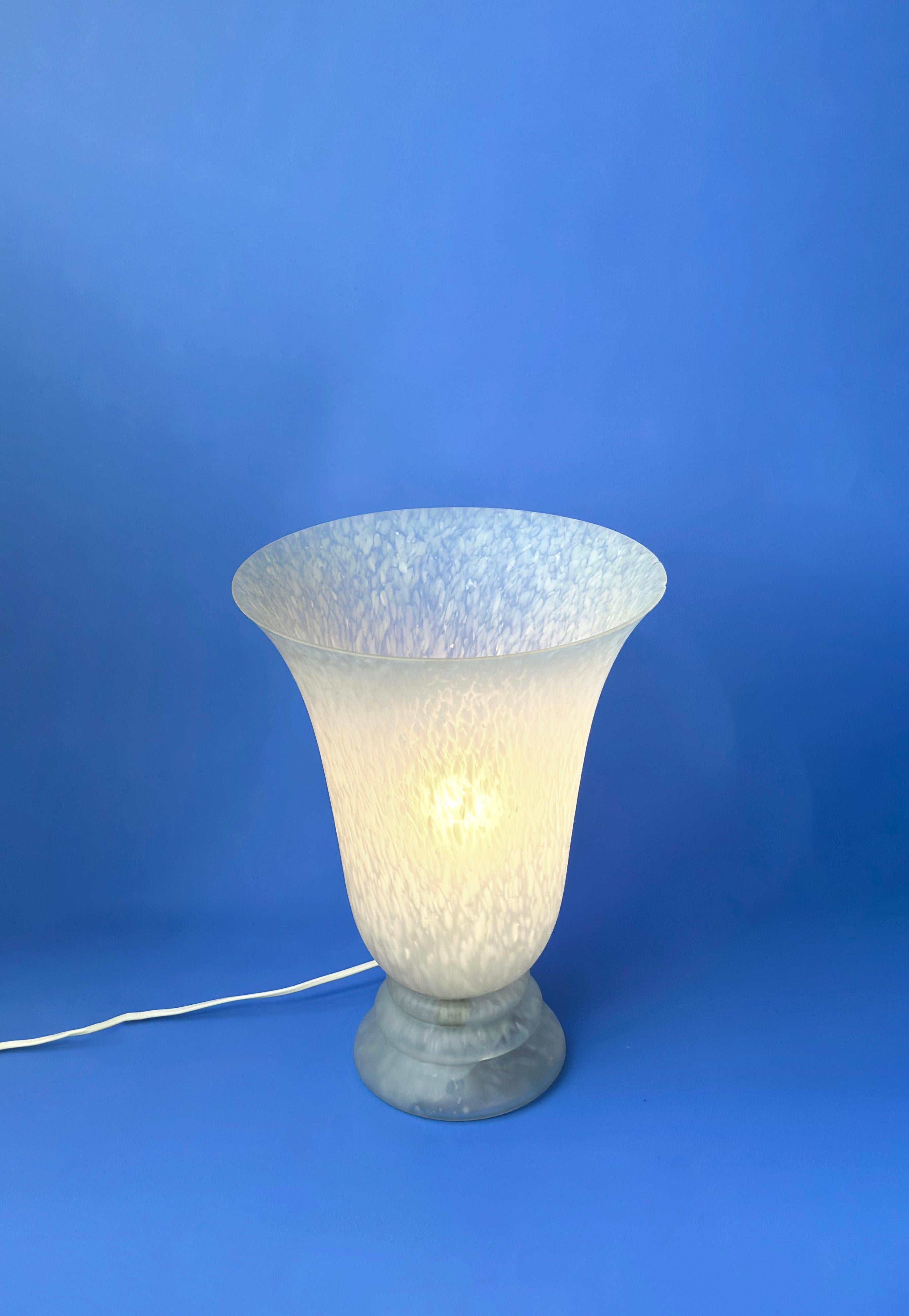 A vintage glass art deco style torchiere table lamp.

Crafted from soft dove grey and white rolled glass, the lamp's single-piece construction—both shade and base—exhibits a skilled blend of glass-blowing and moulding skills. The glass has been acid