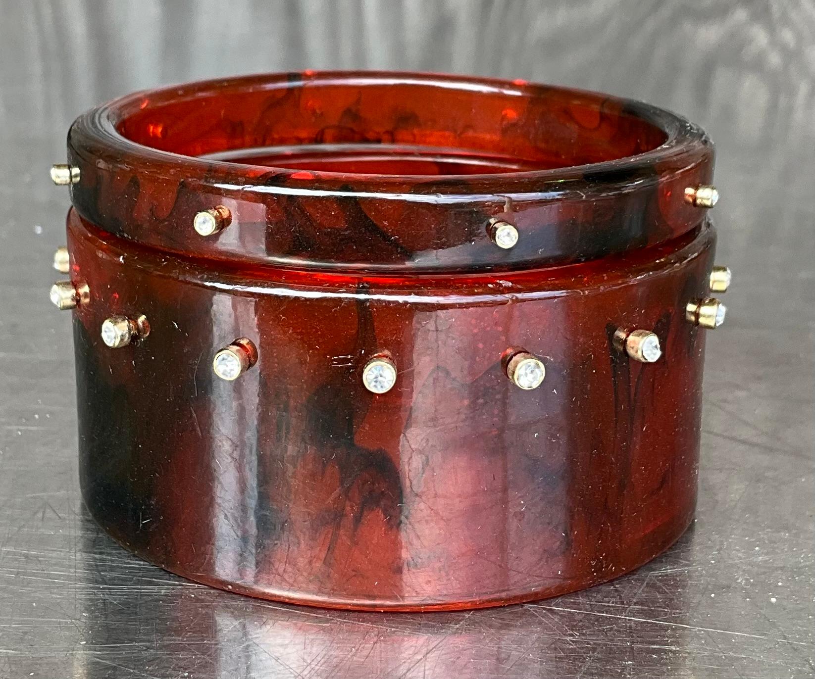 Questo set di braccialetti in lucite tartaruga vintage è composto da braccialetti in lucite, un materiale acrilico trasparente noto per la sua durata e la sua finitura lucida. Il motivo tartaruga è tipicamente un mix di tonalità marroni, ambrate e