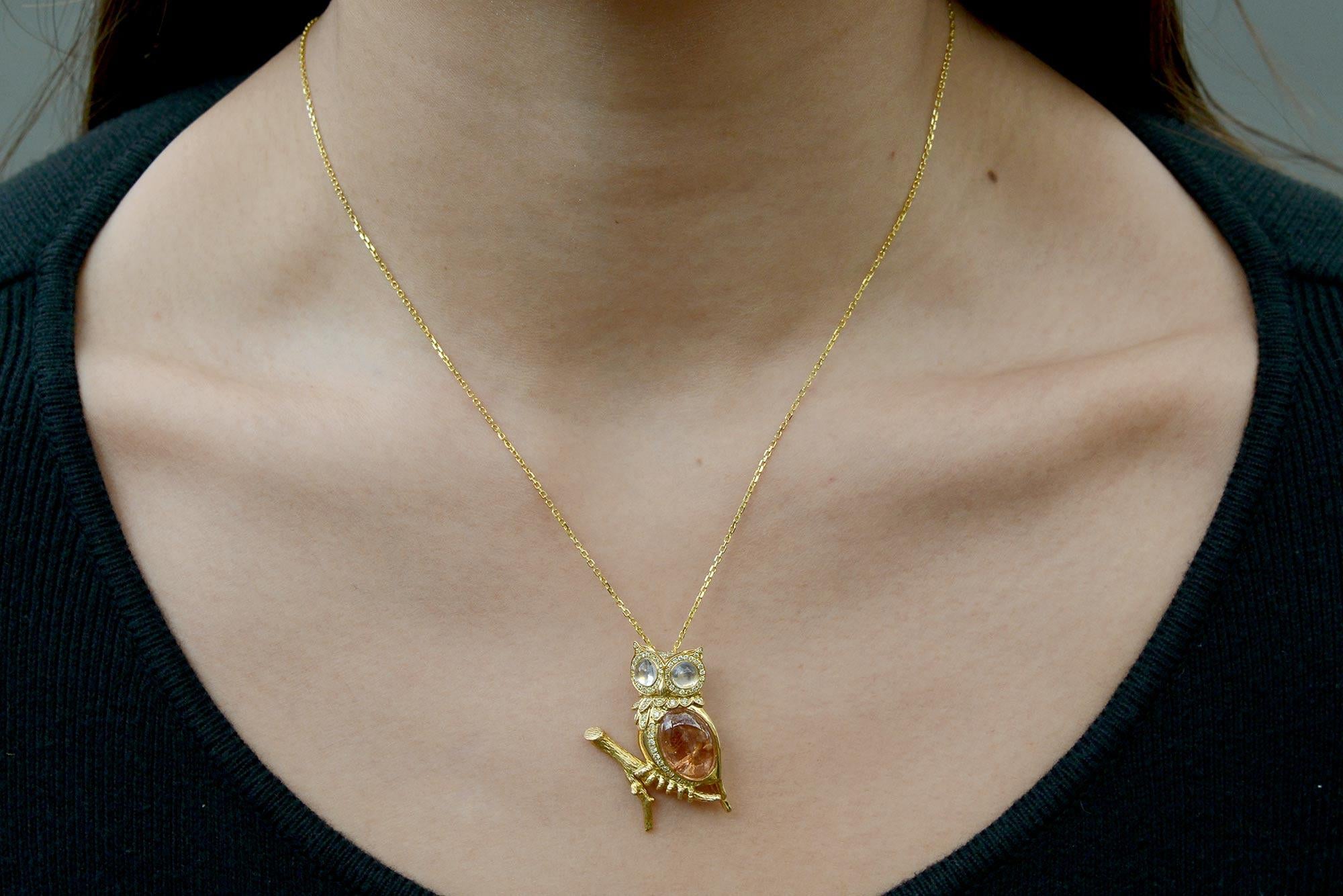 This vintage owl necklace is a hoot! Presenting an 18k yellow gold owl with glowing moonstone eyes and an illuminating peachy orange tourmaline breast with intriguing characteristics. This lavish bird is further embellished with 65 diamond