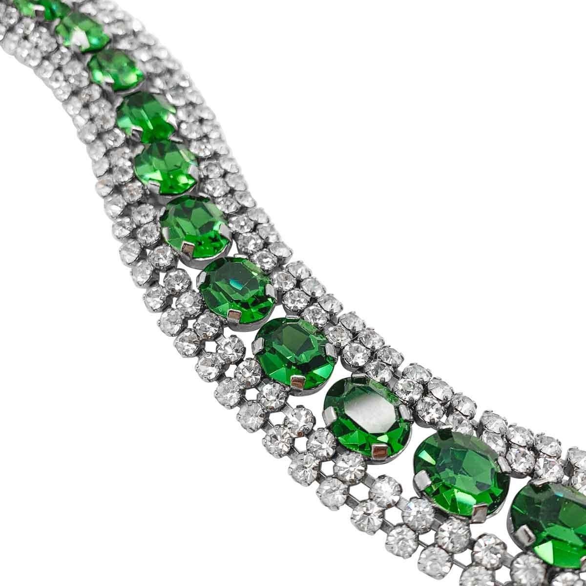 A Vintage Tourmaline Crystal Bracelet. Featuring a line of large tourmaline green fancy cut oval crystals edged with a double row of white crystal chatons on either side. Each stone claw set.
Vintage Condition: Very good without damage or noteworthy
