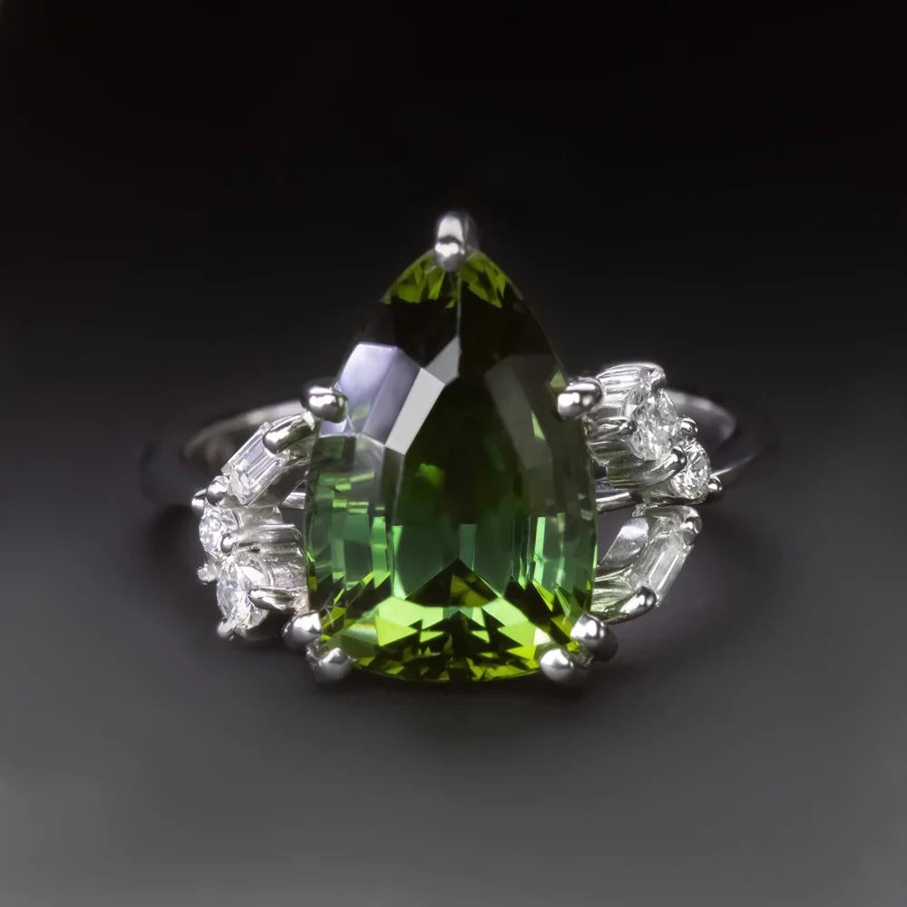 Introducing a truly remarkable piece of jewelry, this vintage tourmaline and diamond cocktail ring exudes sophistication with its exquisite design. At its heart lies a substantial 6 carat natural green tourmaline, boasting a captivating