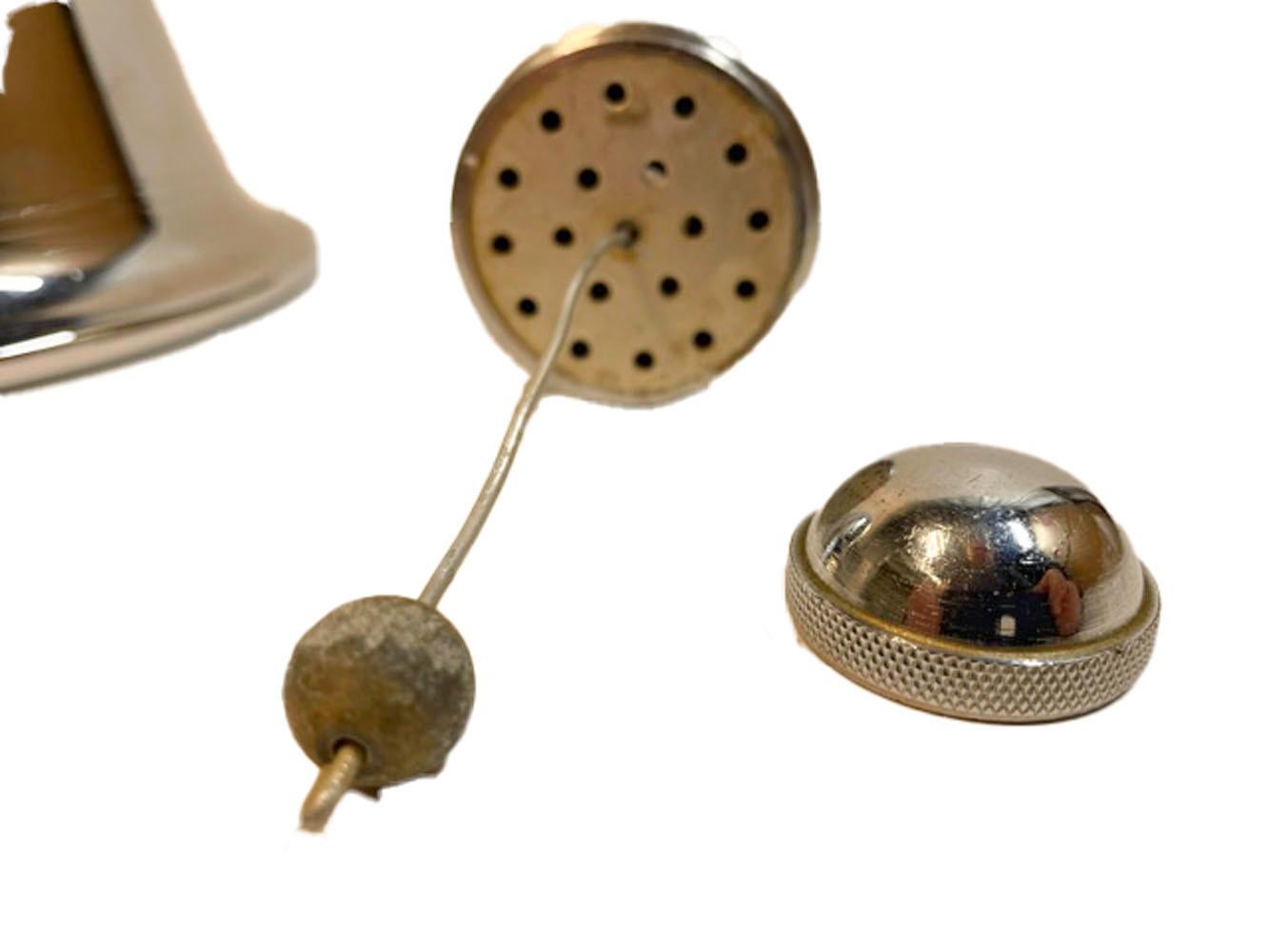 Mid-century cocktail shaker in the form of a large hand held bell. Unscrew the wood handle from the top of the bell, fill with ice and cocktail ingredients, replace the handle and shake. Then remove the cap from the top of the handle and pour.