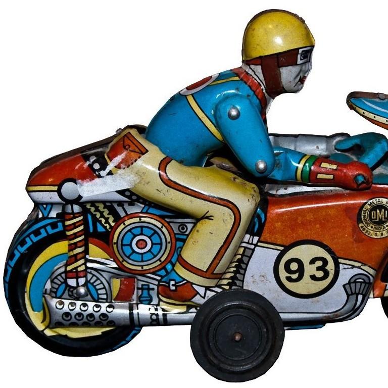 Der Motorradfahrer von Oriental Metal Industries ist ein historisches mechanisches Spielzeug aus den 1970er Jahren.

Vintage Metallspielzeug, das einen großen Motorradfahrer auf seinem Motorrad darstellt.

Hergestellt in Indien von Oriental
