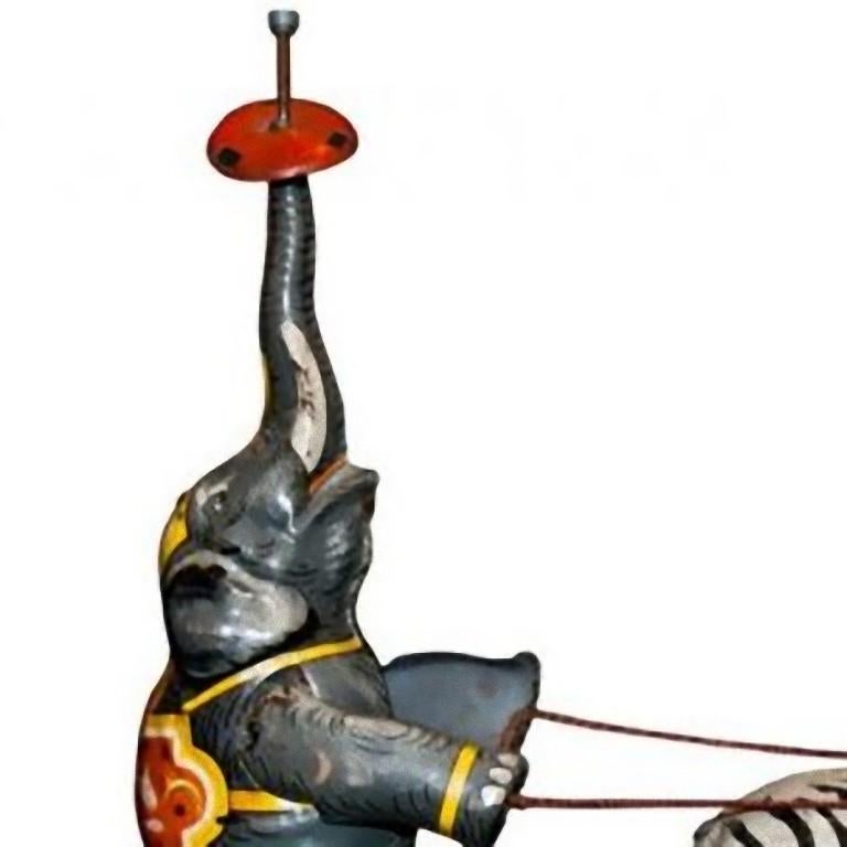 This wind up elephant and zebra circus is an original vintage toy.

Vintage wind up mechanical toy, representing an elephant driving a chariot dragged by a zebra.

The toy was made in the U.S. zone Germany in 1940s.

The groups of stacked