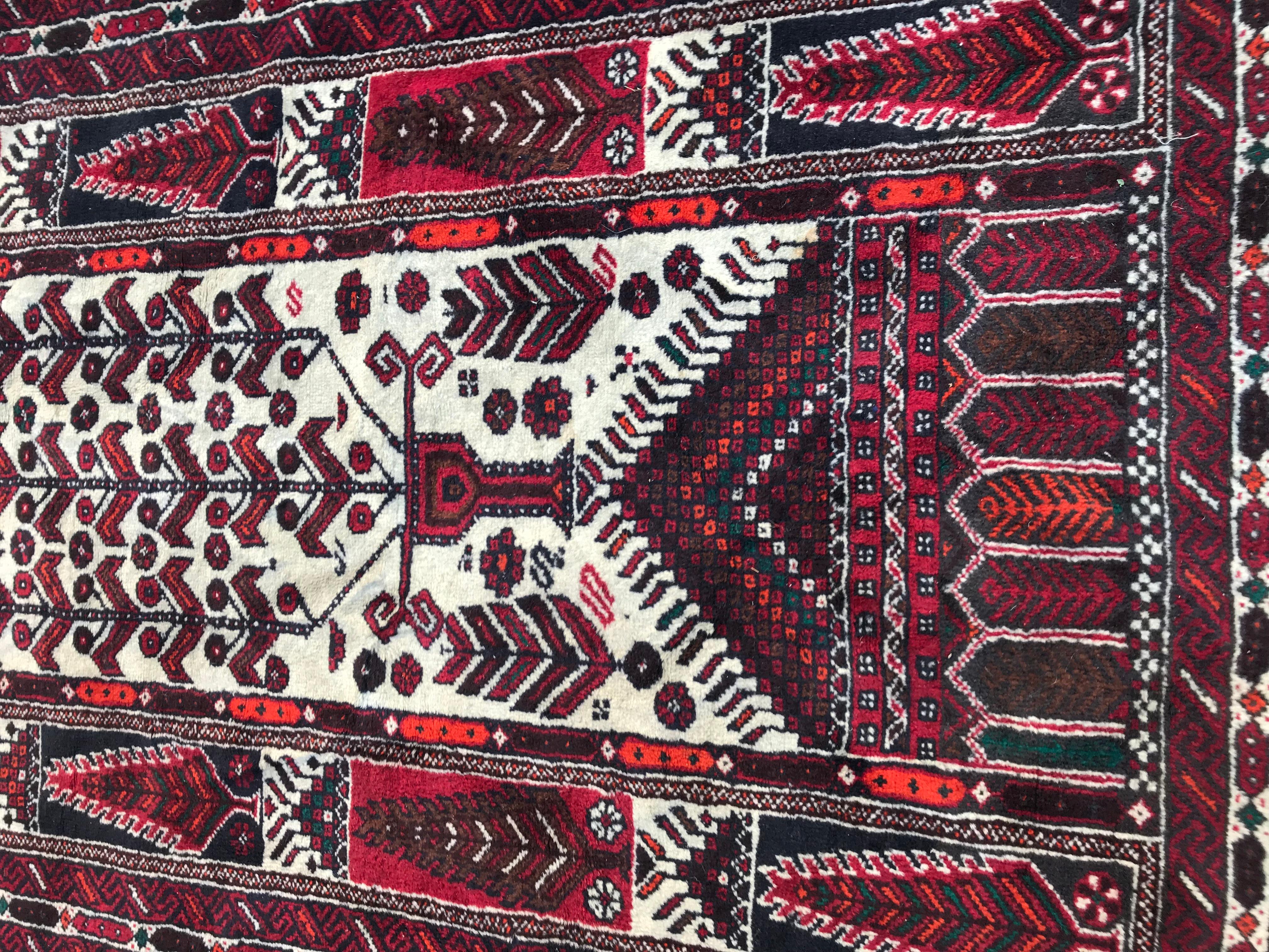 Beautiful 20th century Afghan Baluch rug with a tribal design and nice colors with red, black, orange and purple, entirely hand knotted with wool velvet on cotton foundation.