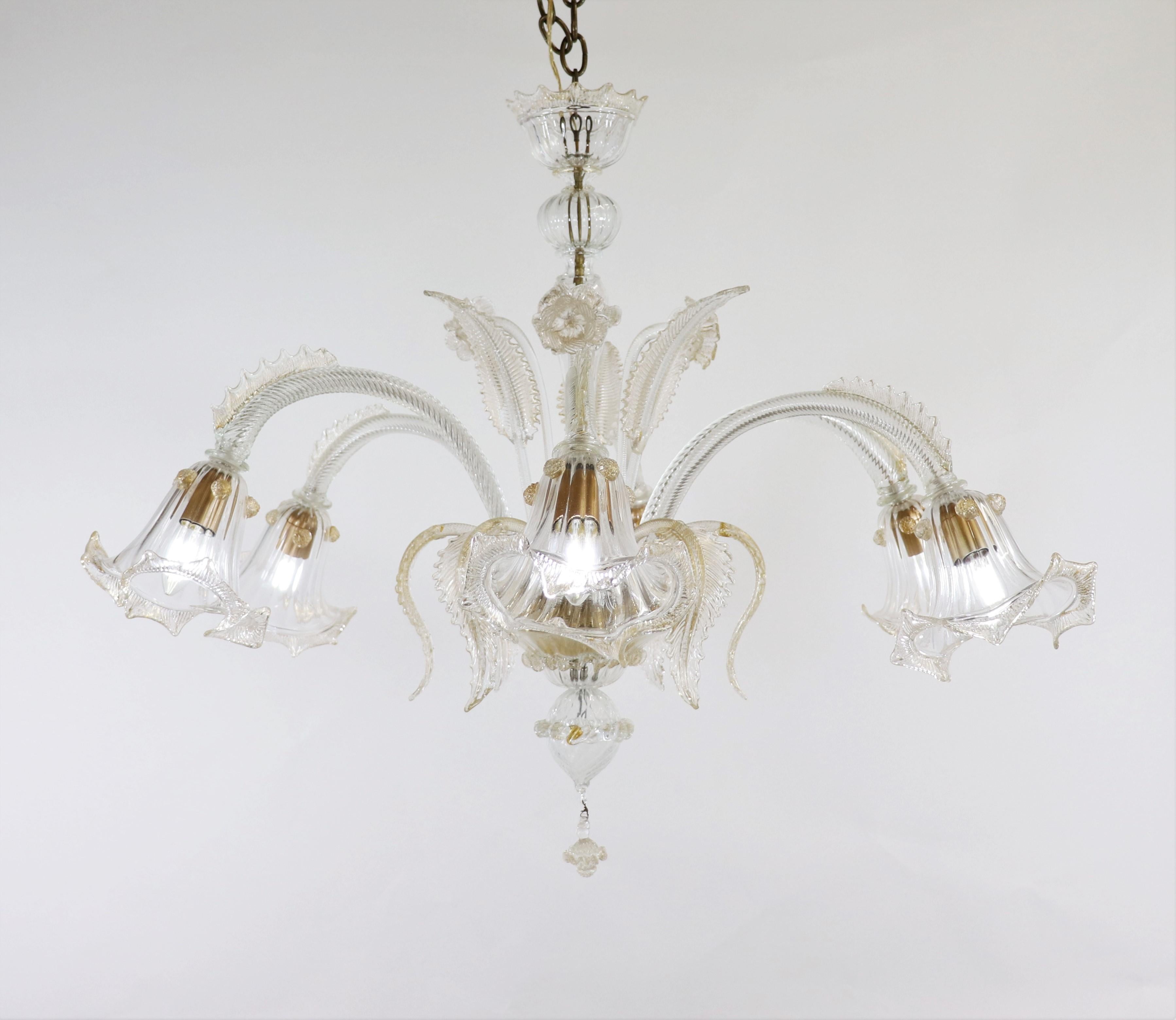 This handcrafted gold-infused cristallo Murano floral chandelier has six scroll arms with tri-lobed cups, with fin-like spines on the curve of the arms. Featuring a bulbous center column with blooming details, stylized here with daffodils and