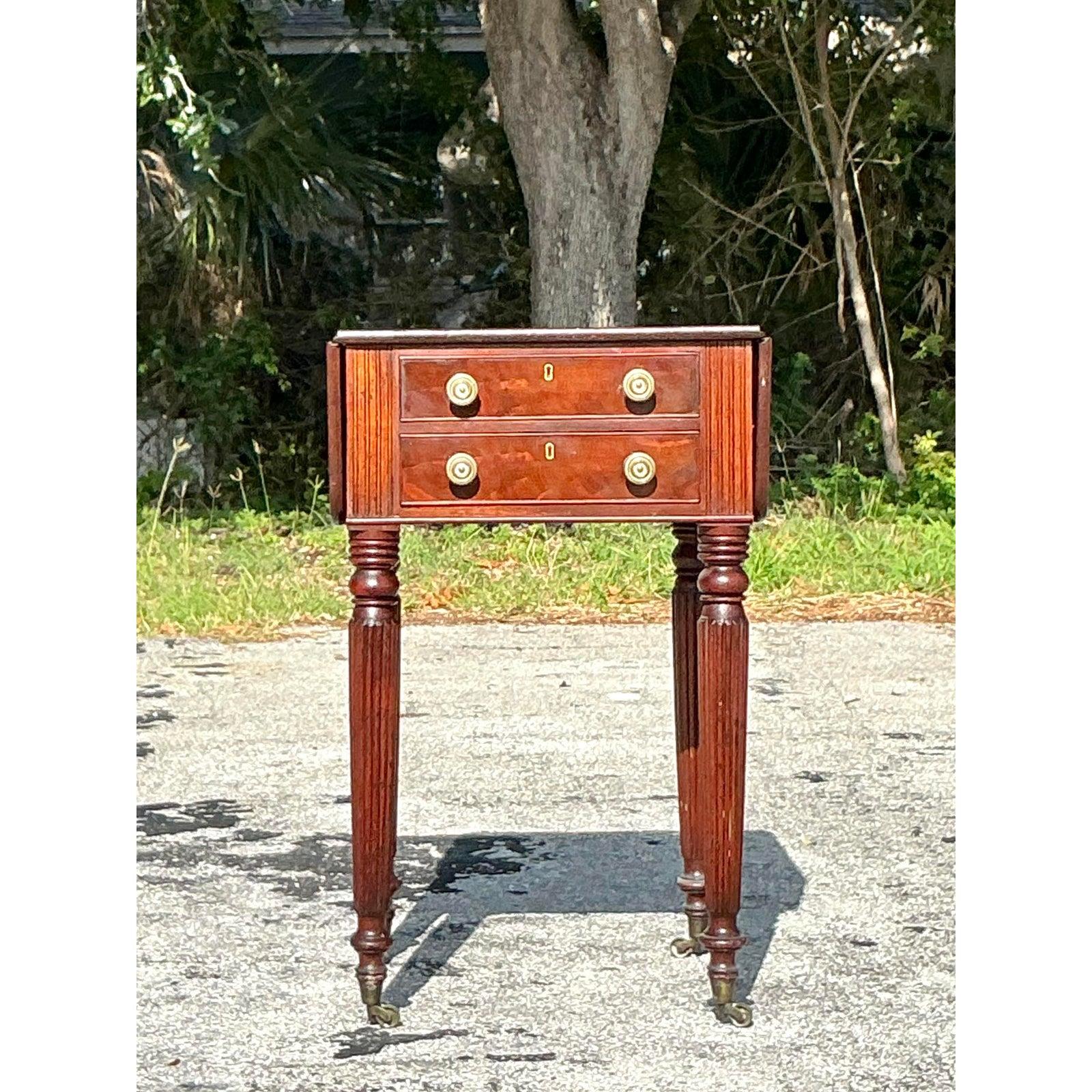 Cette charmante table d'appoint vintage à plateau rabattable incarne l'élégance classique avec sa riche finition en acajou, ses pieds cannelés et sa quincaillerie intemporelle en laiton. Fabriquée de manière experte avec des détails traditionnels,